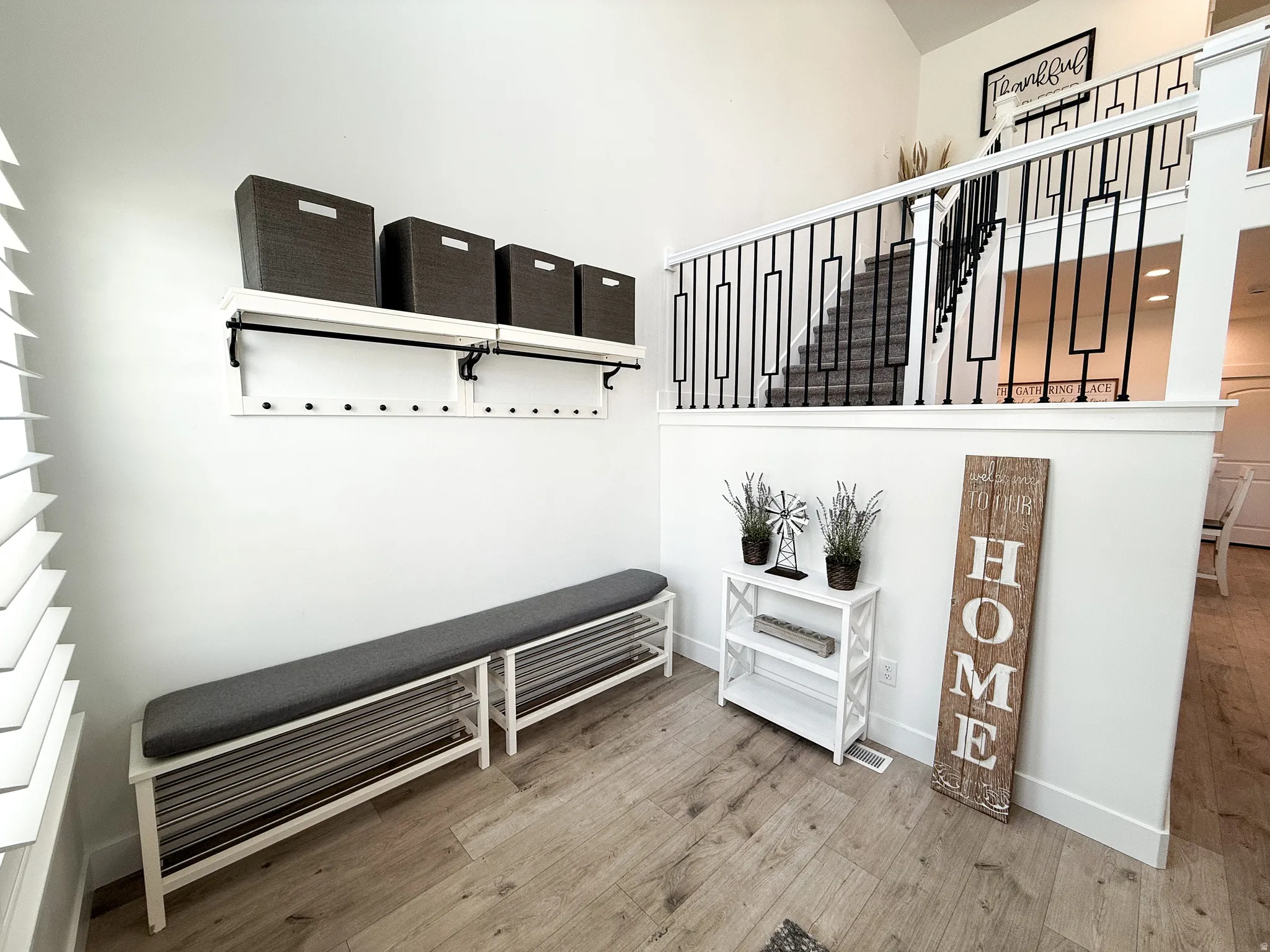 Open entryway with wood-finish flooring and white baseboards