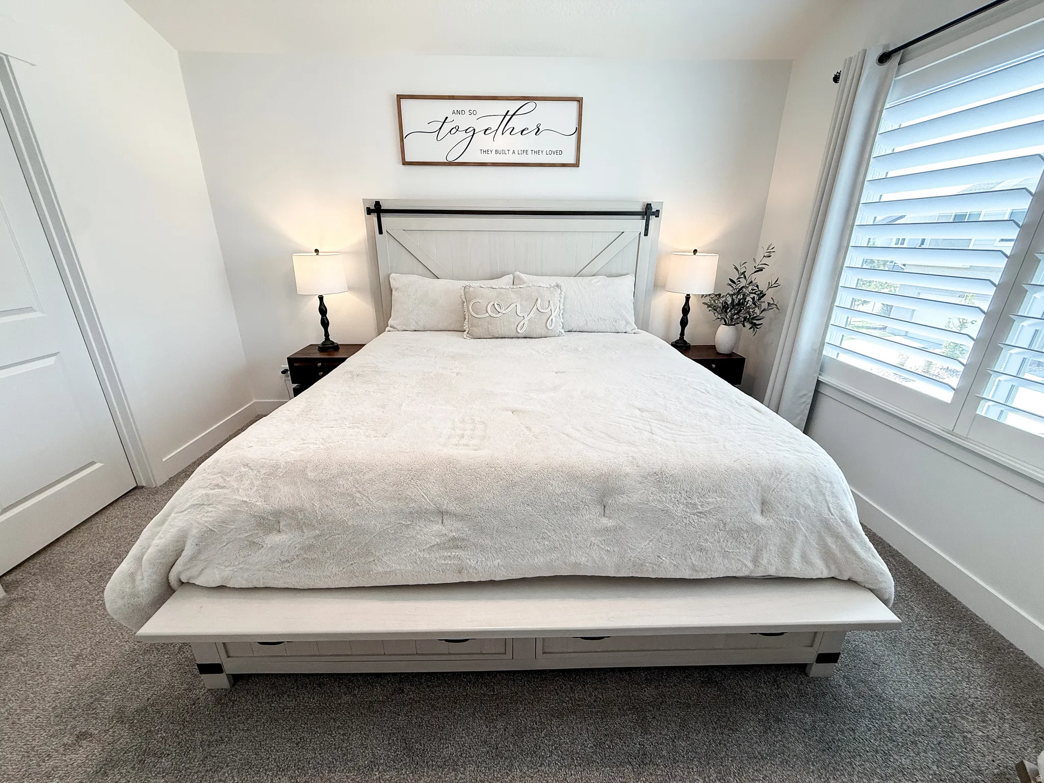 Spacious bedroom featuring neutral carpeting and white walls