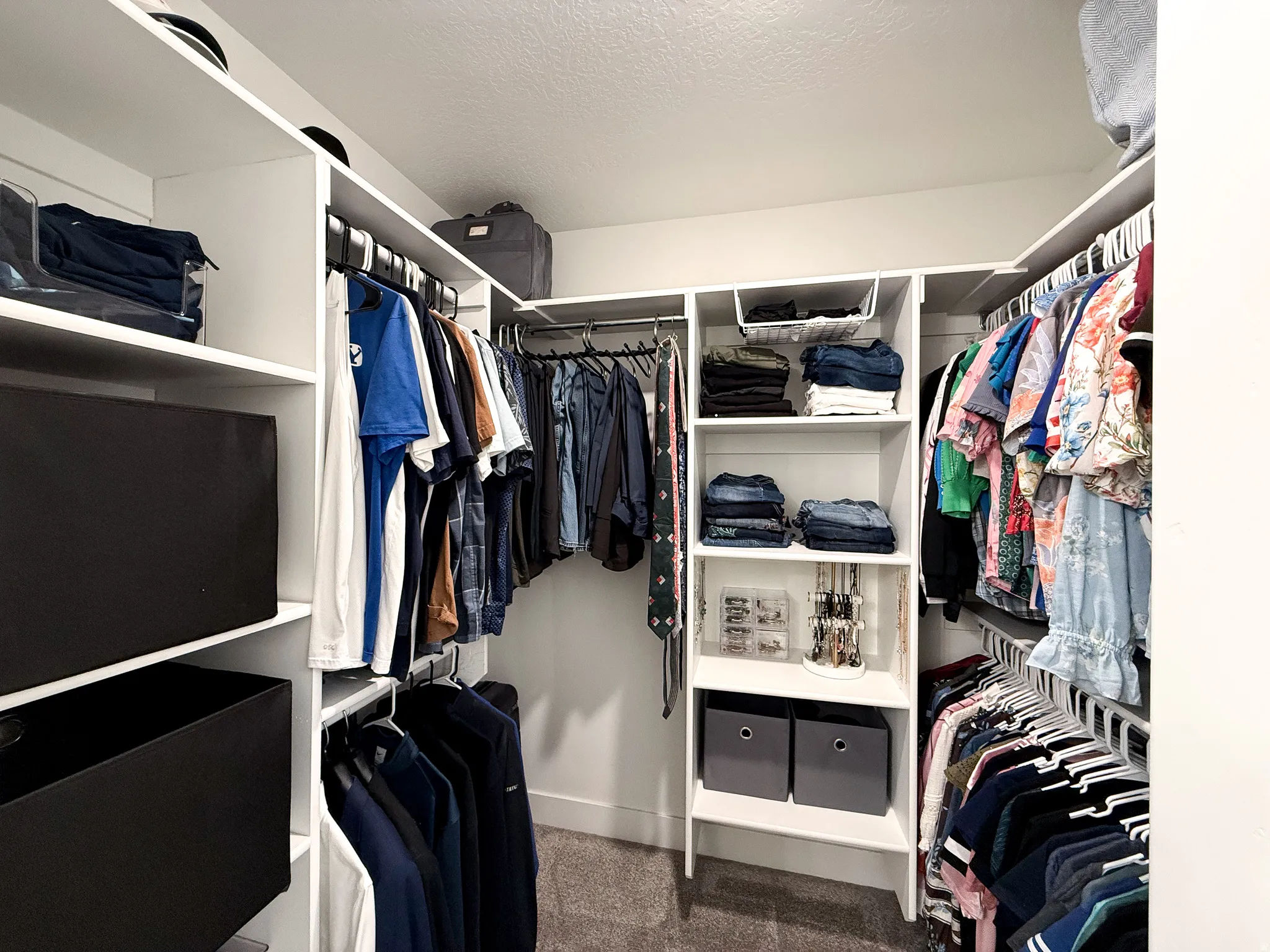 Custom walk-in closet featuring built-in shelving, multiple hanging rods, and recessed ceiling lighting