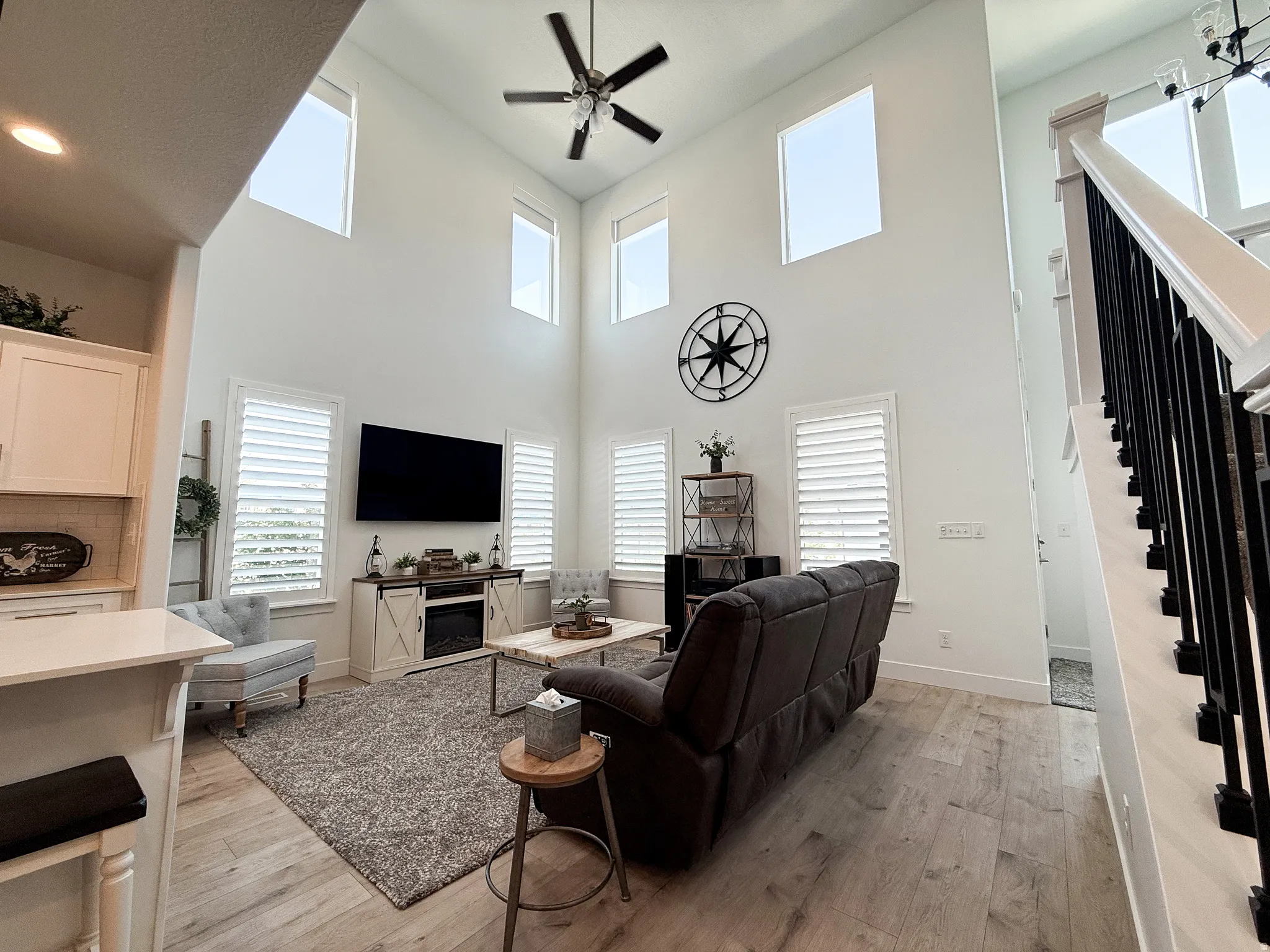 Soaring ceilings featuring high-level windows, a ceiling fan, and recessed lighting
