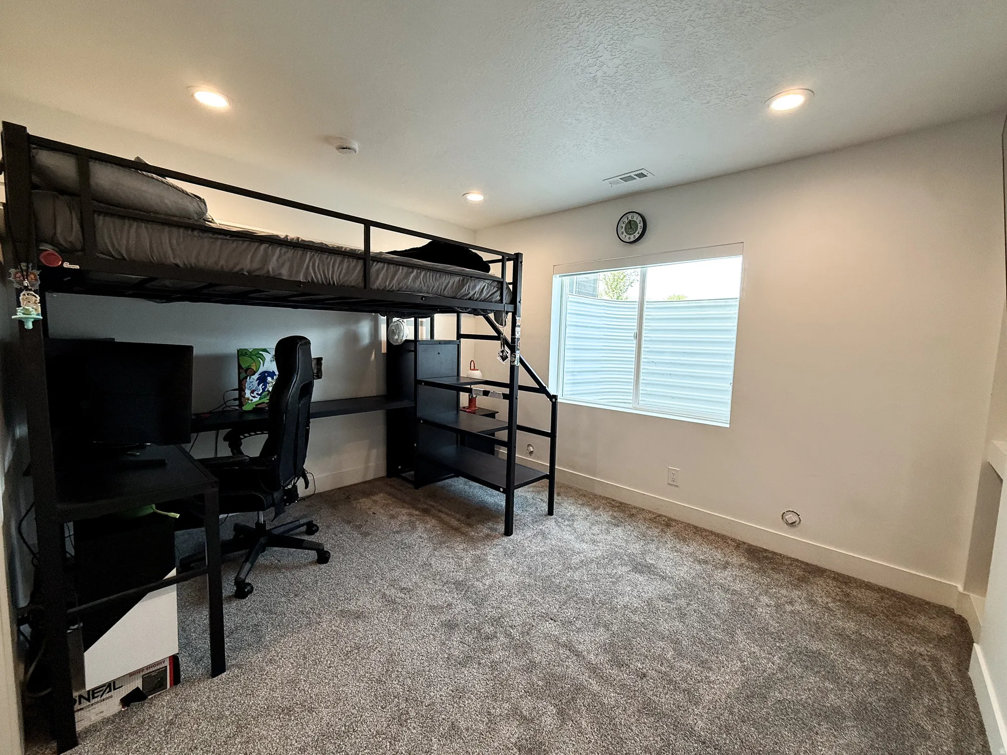 Spacious room featuring neutral carpeting, white baseboards, and recessed lighting
