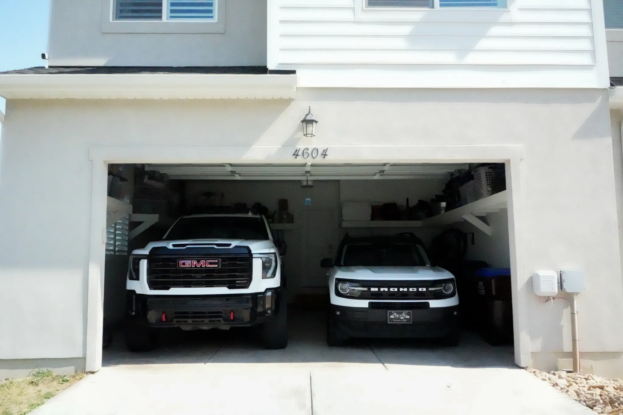 Two-car garage with overhead shelving and exterior wall sconce