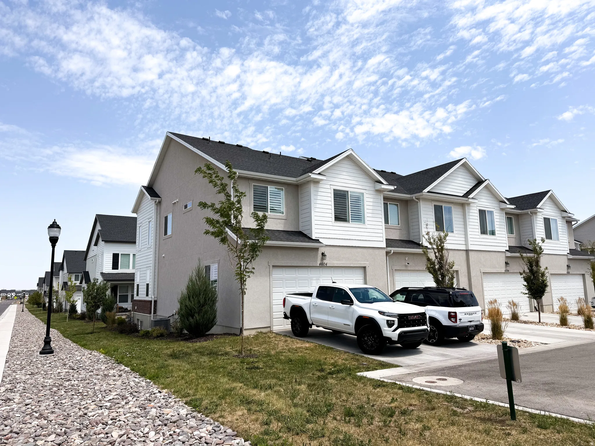 Modern townhome exteriors featuring white siding and light gray stucco