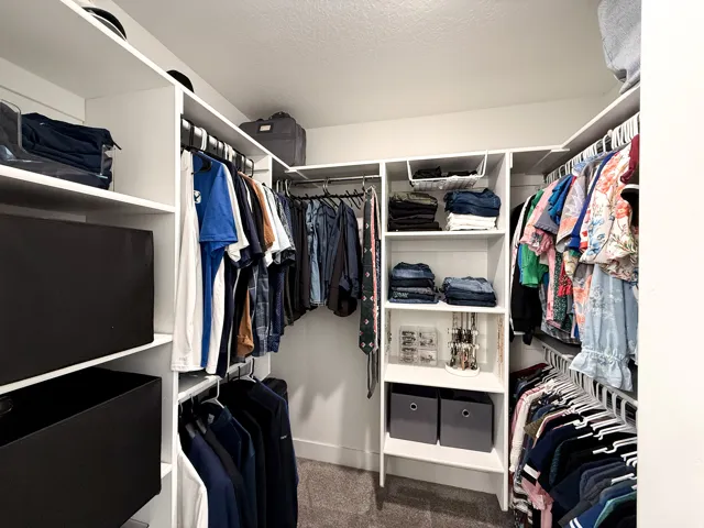 Custom walk-in closet featuring built-in shelving, multiple hanging rods, and recessed ceiling lighting
