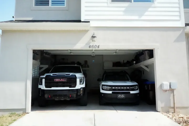 Two-car garage with overhead shelving and exterior wall sconce