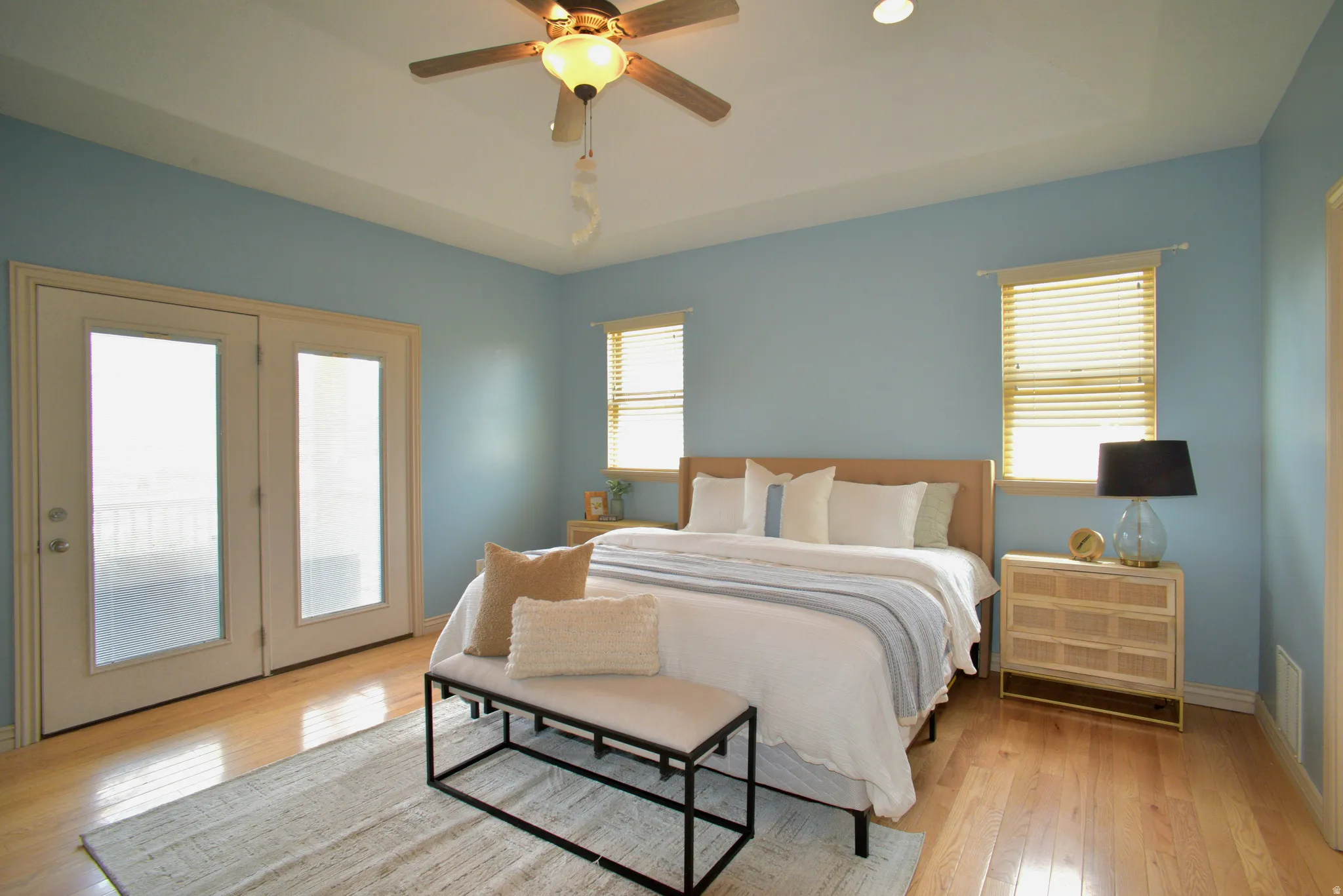 PRIMARY BEDROOM WITH WALKOUT TO COVERED DECK AND HARDWOOD FLOORS