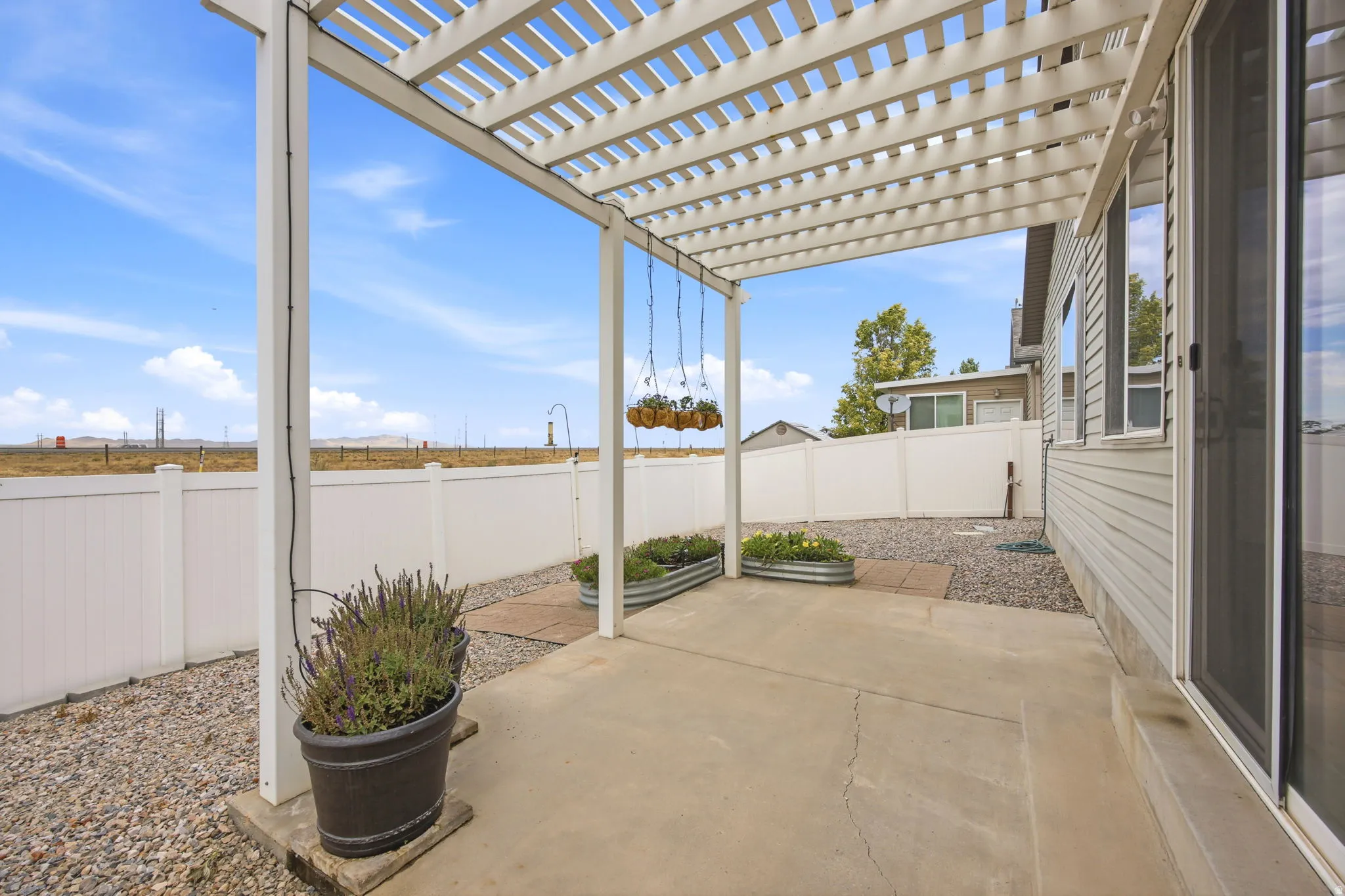 Outdoor patio area featuring a white slatted pergola