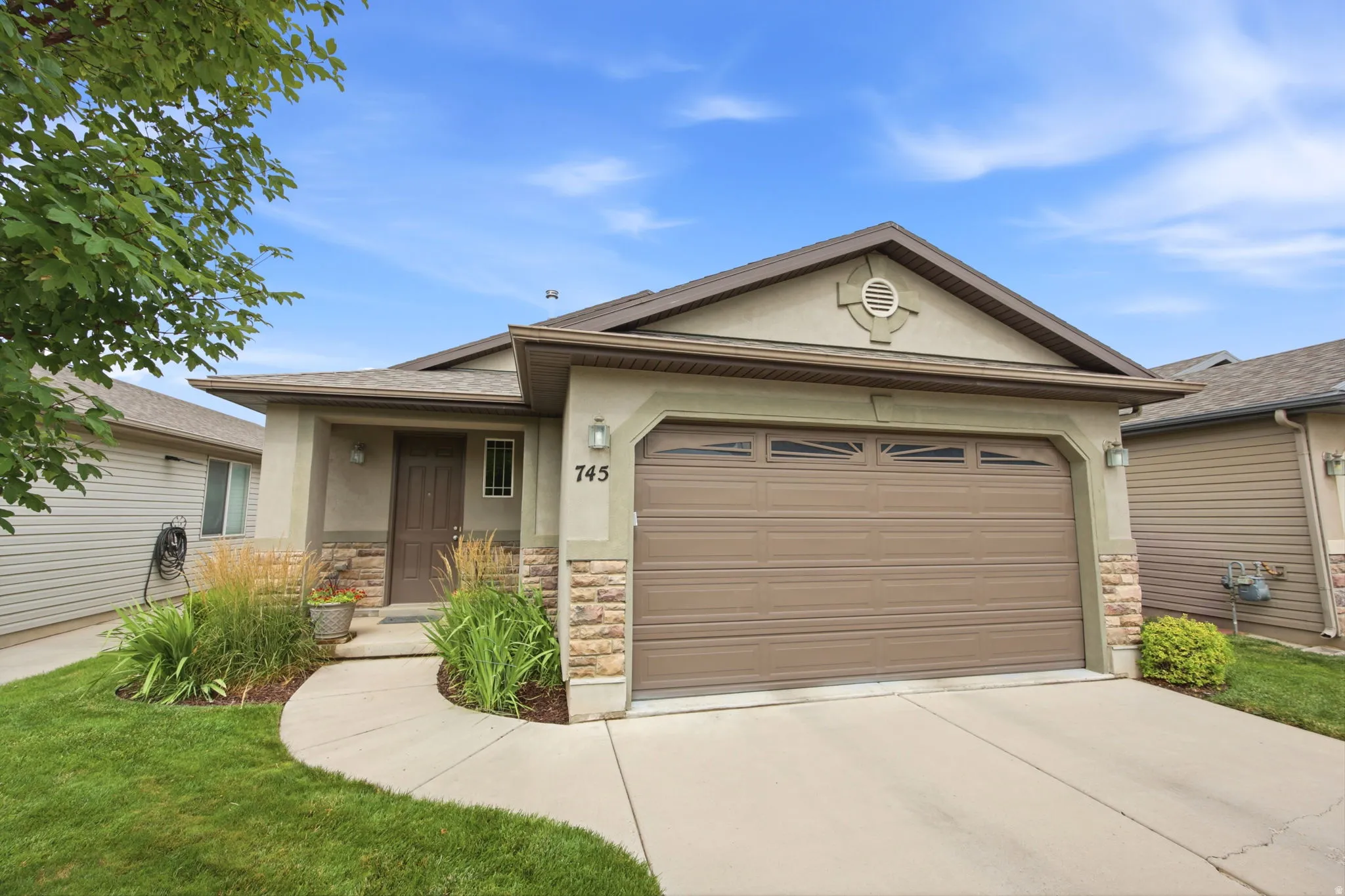 Stucco and stone facade with a two-car garage and concrete driveway