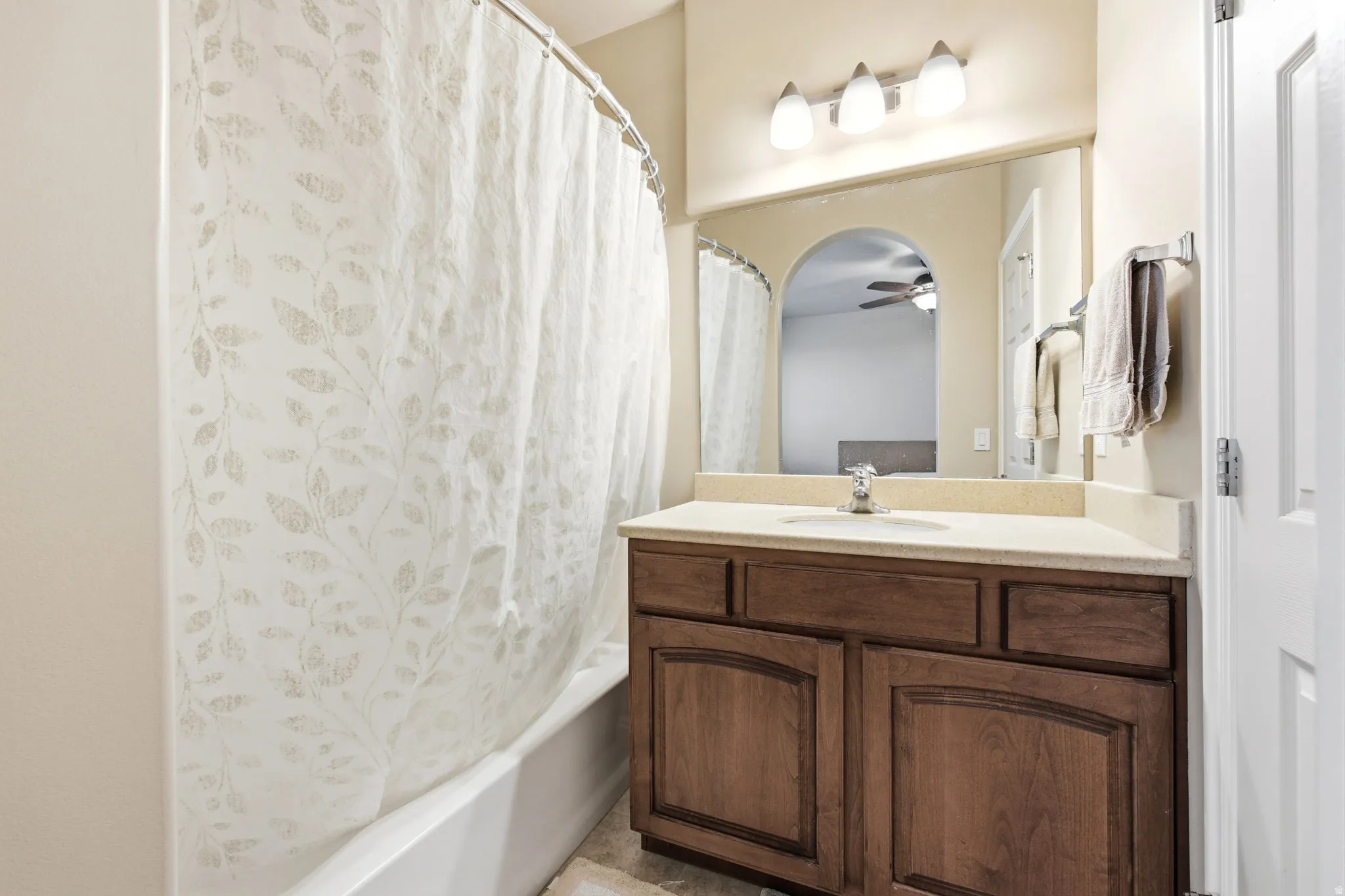 Bathroom vanity featuring a light-toned countertop with an integrated sink and a chrome faucet