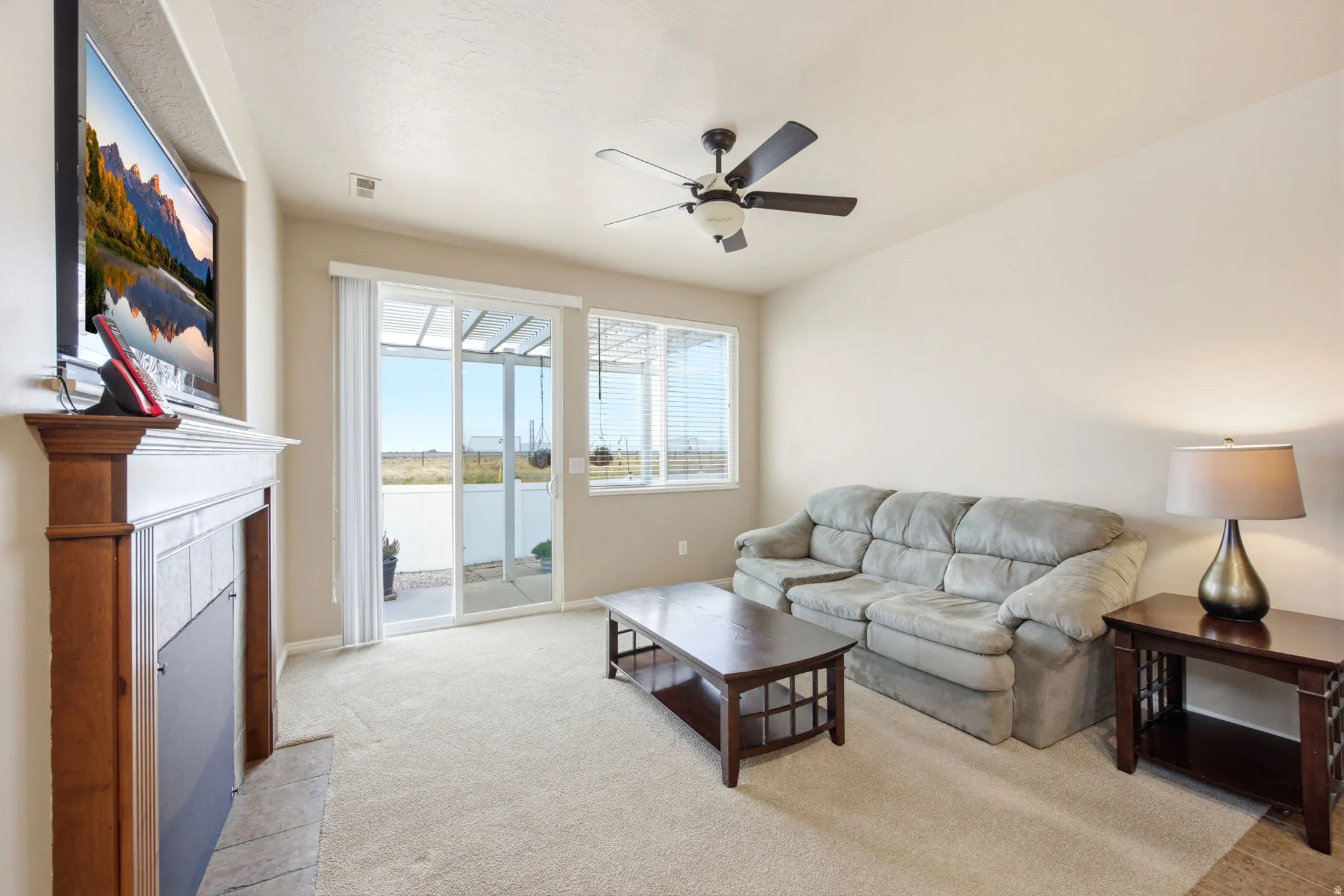 Living area featuring a fireplace with a wood mantle and tile surround