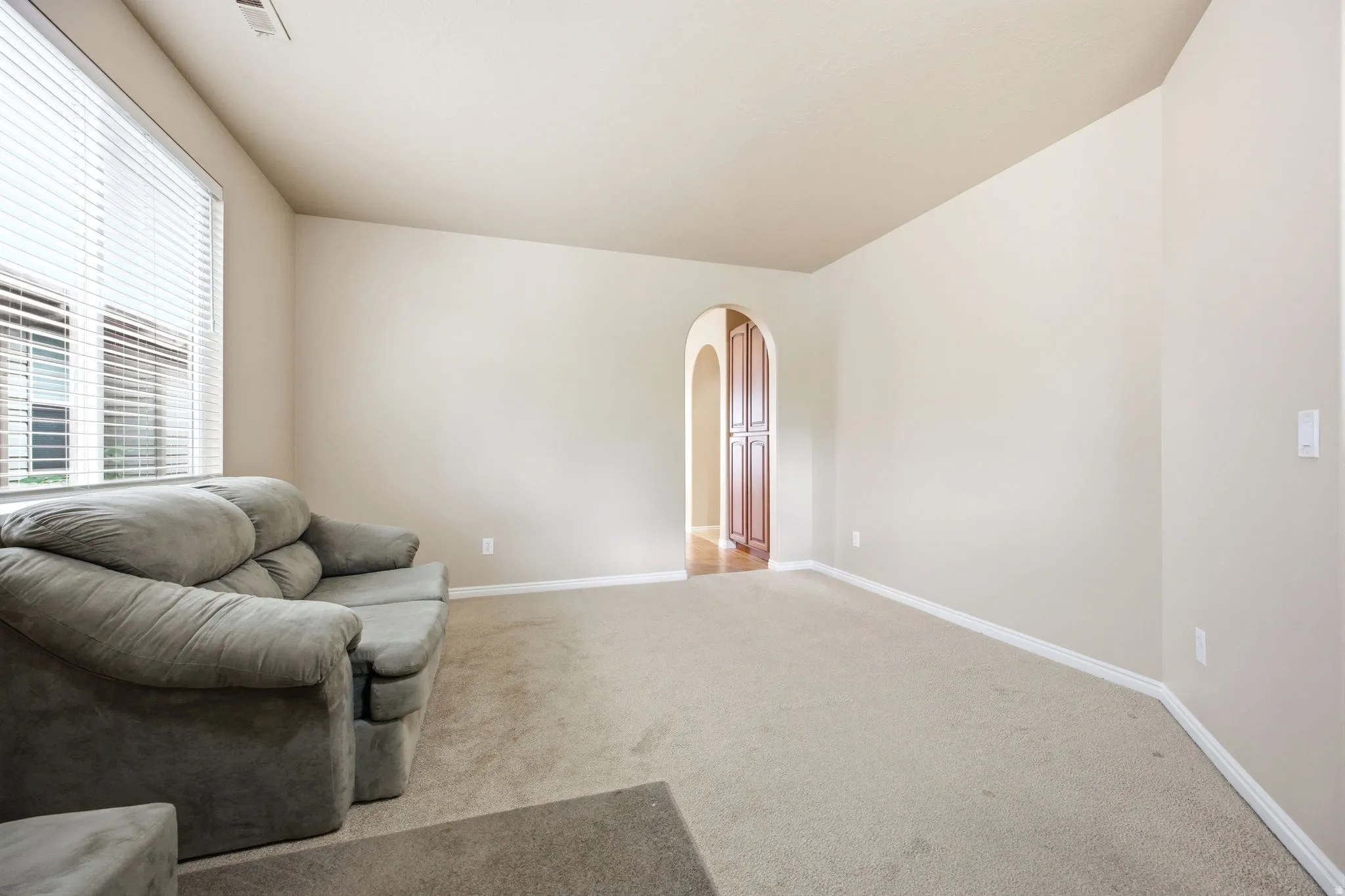 Spacious living area featuring neutral carpeting and light-toned walls