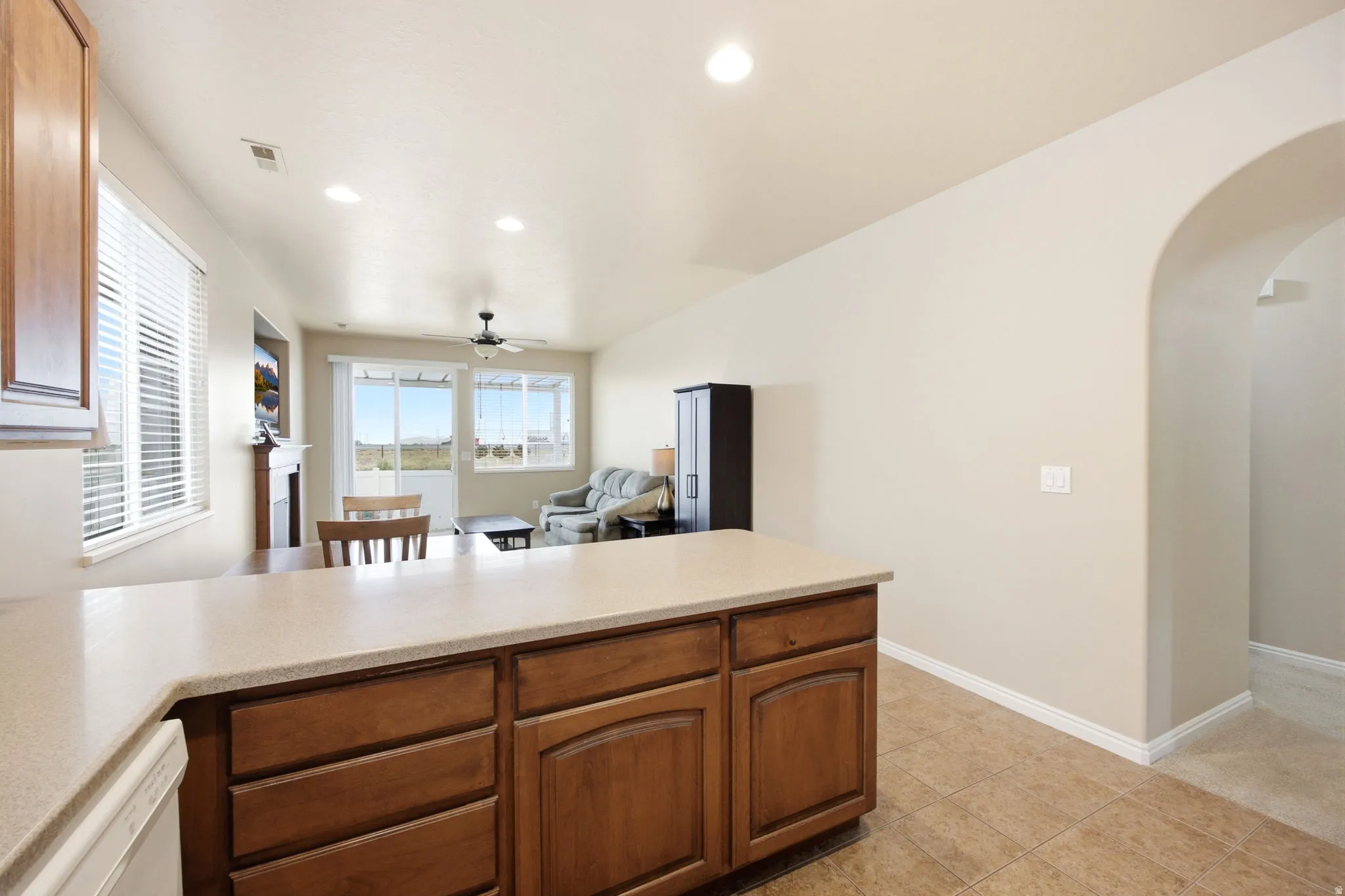 Kitchen island with wood-finish cabinetry and a light-toned countertop