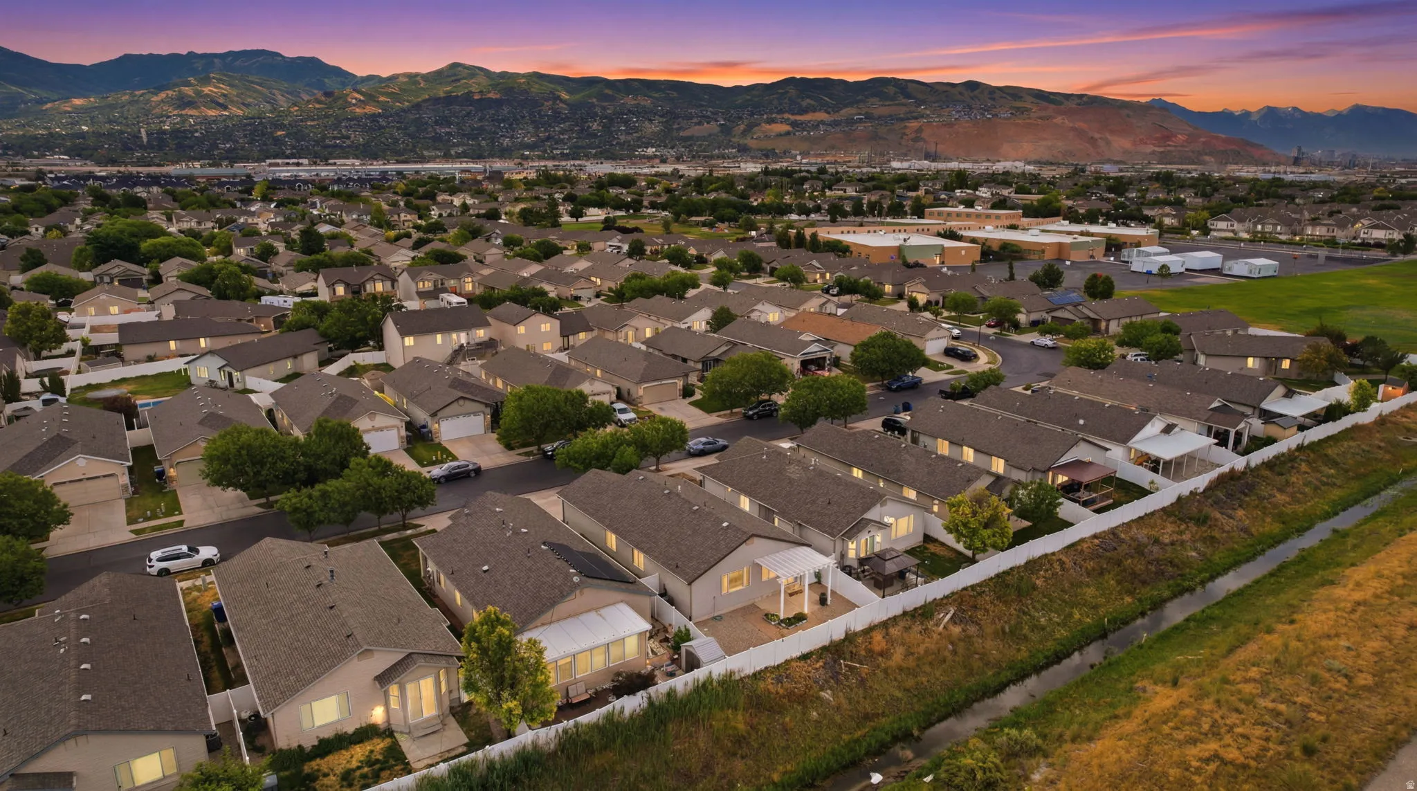 Aerial perspective of a residential neighborhood featuring numerous single-family homes with gray shingle roofs
