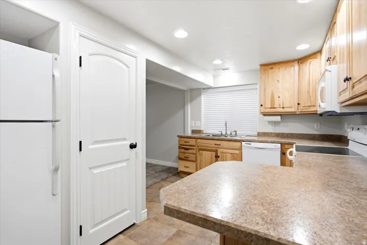 Kitchen featuring wood cabinetry, stone-finish countertops, and tile flooring