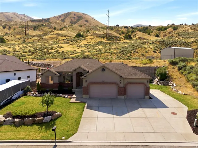 Ranch-style residence featuring a brick and stucco exterior, a two-car garage, and a concrete driveway