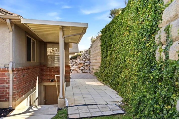 Covered exterior walkway featuring brick and stucco siding