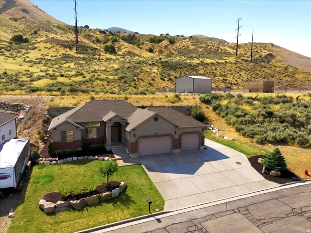 Single-story residence featuring a two-car garage, concrete driveway, and a front lawn with rock landscaping
