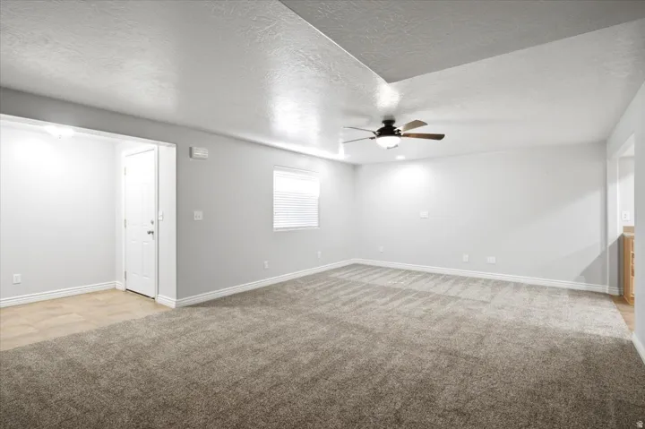 Spacious room featuring textured carpeting and light grey wall finishes