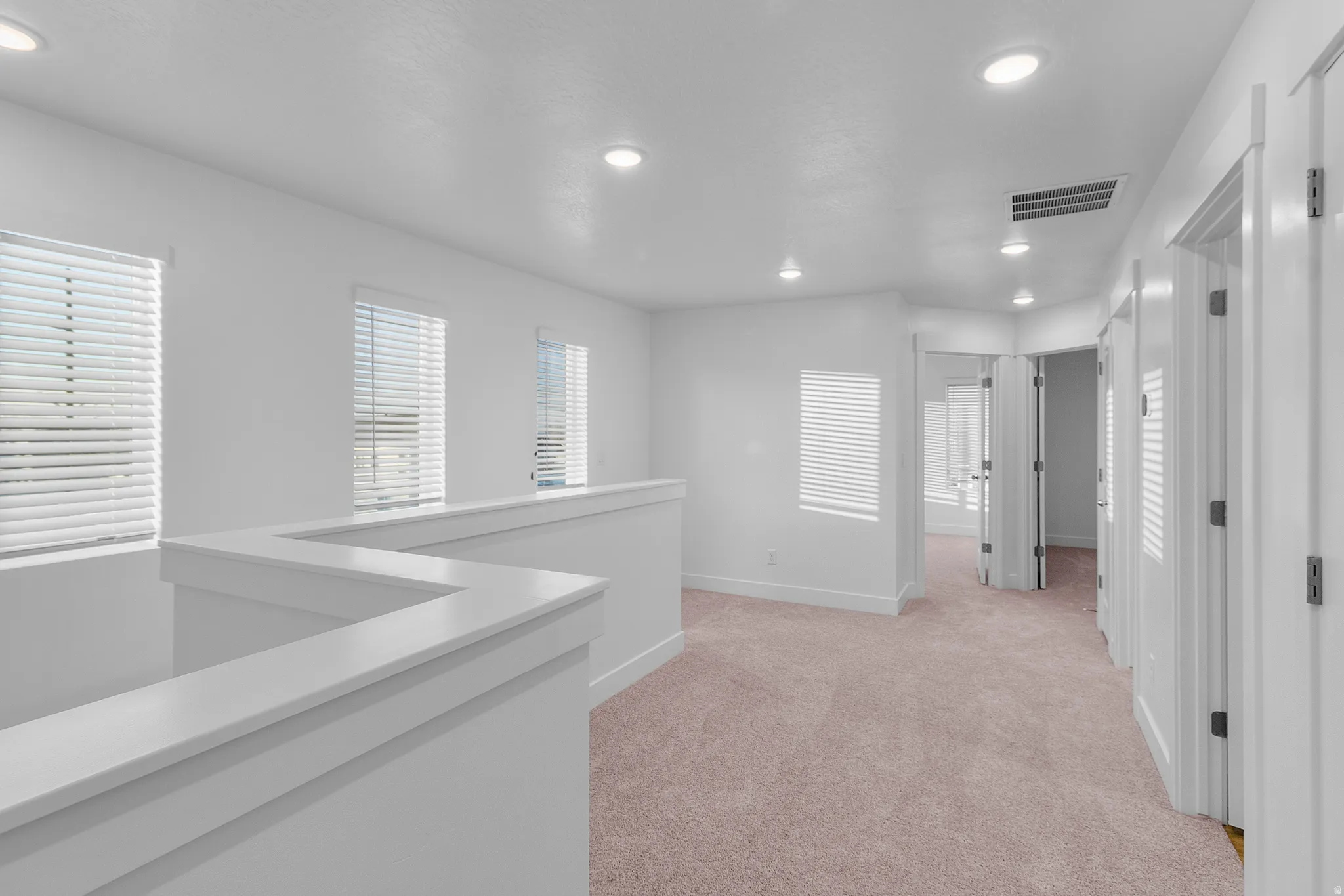 Open hallway with neutral-toned carpet flooring