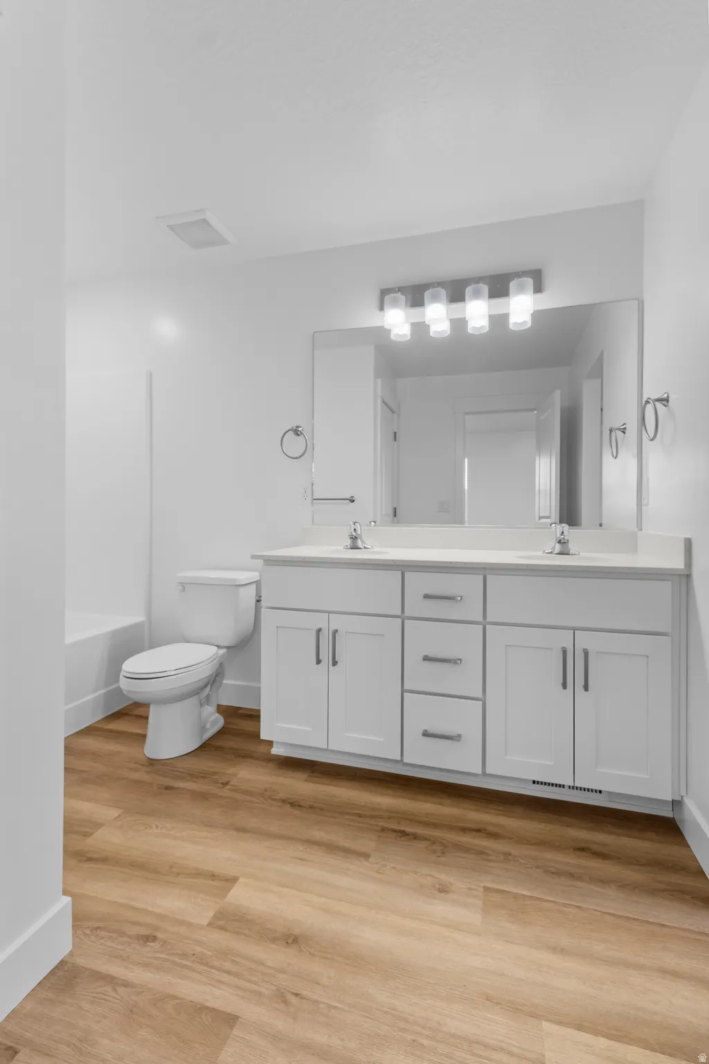 Double vanity with white cabinetry and chrome pulls