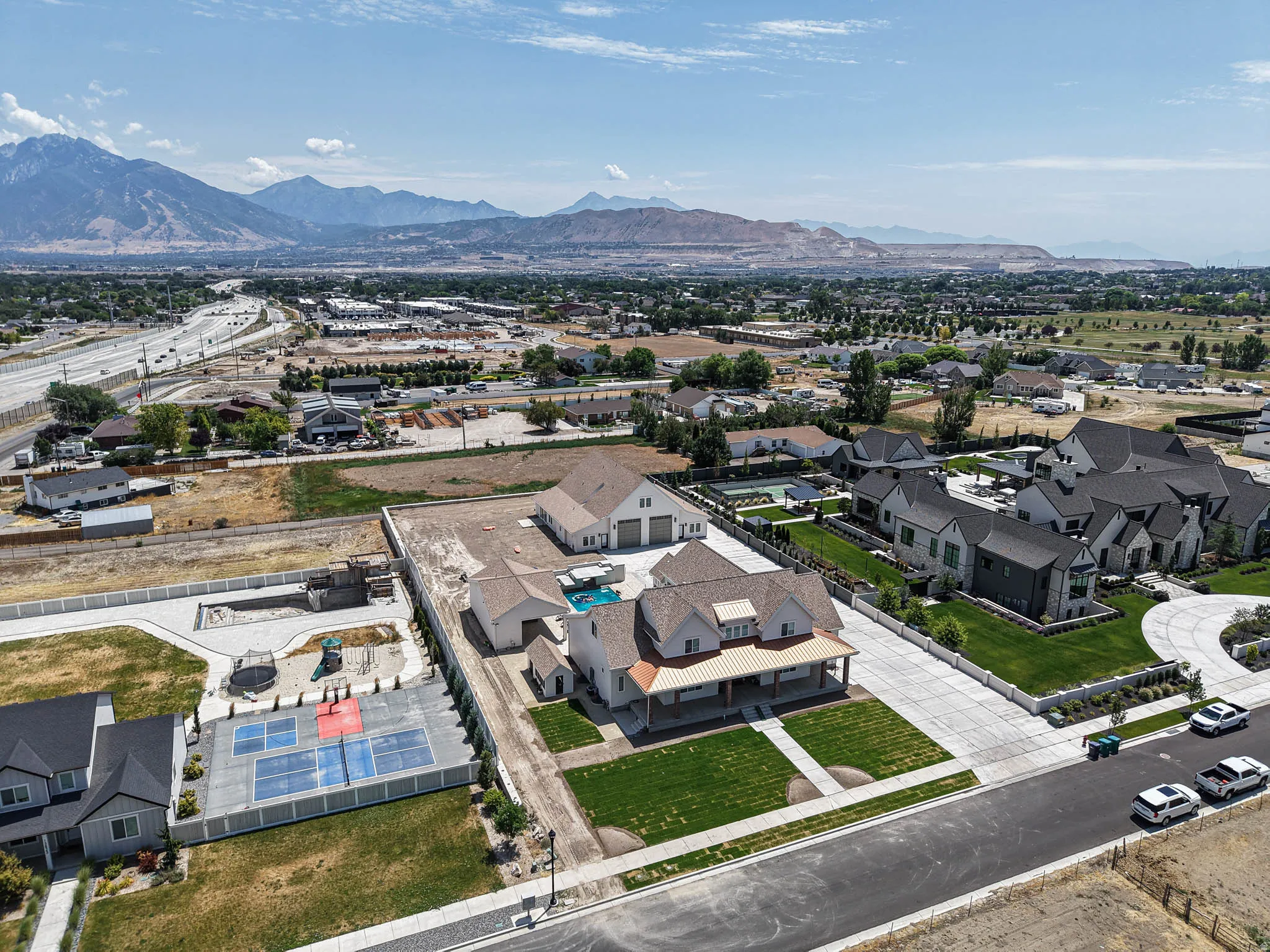 Expansive residential property featuring a large swimming pool, detached garage, and a covered porch