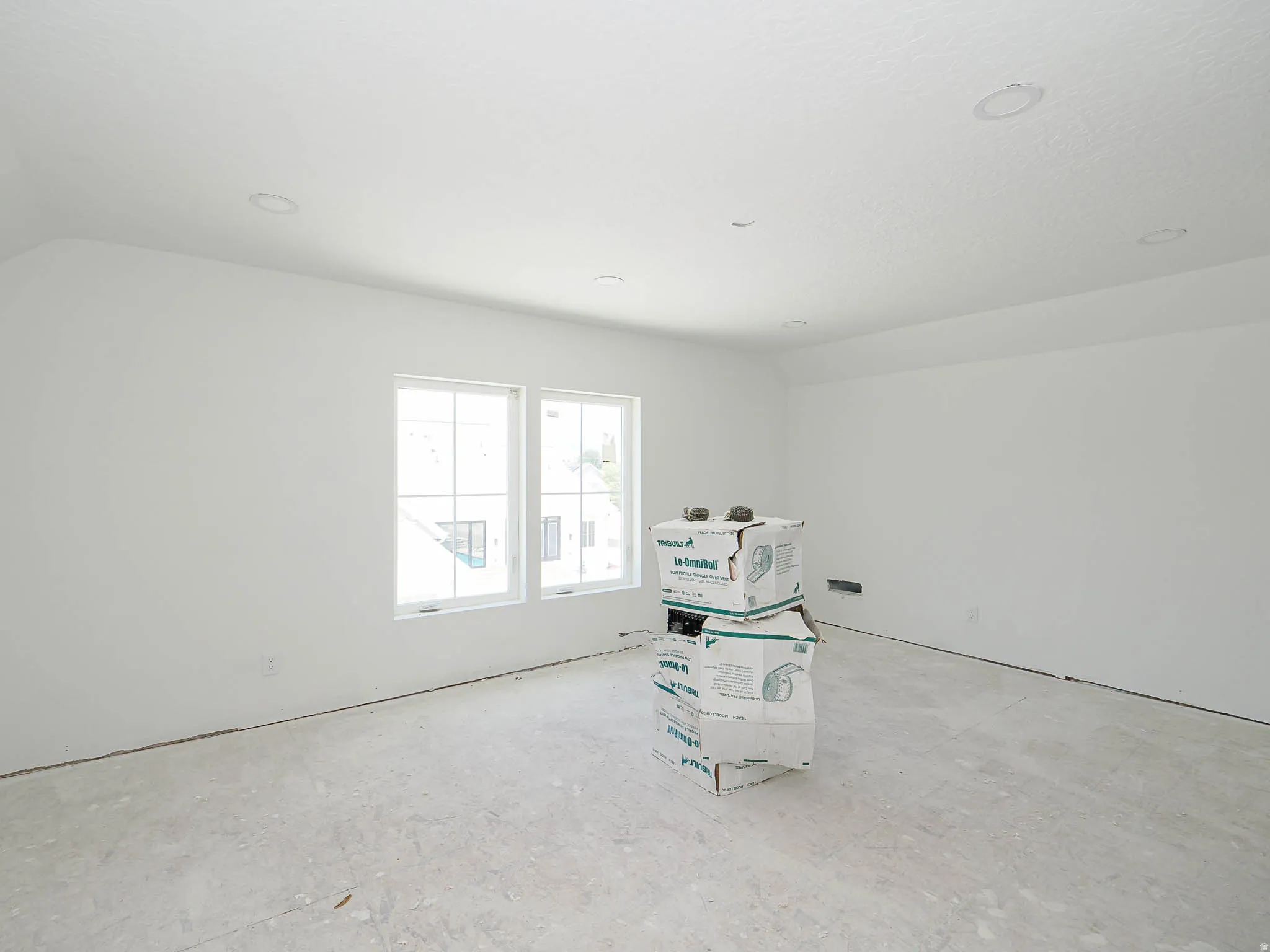 Spacious room with white walls, dual windows, and recessed lighting
