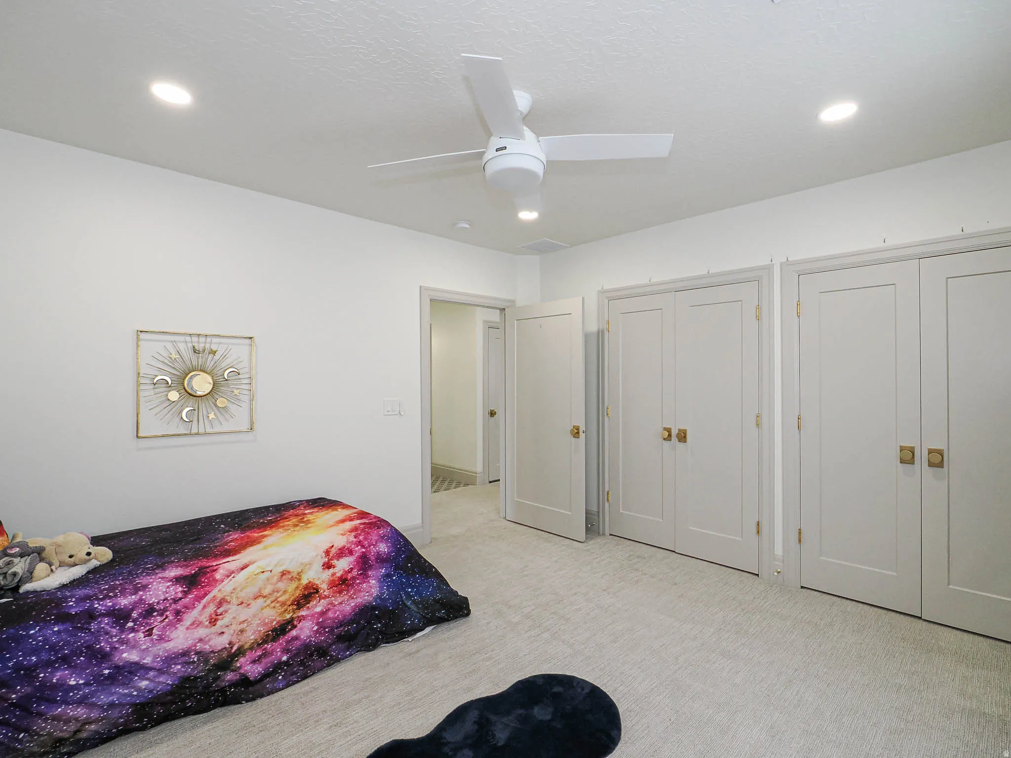 Neutral-toned carpet flooring with recessed lighting and a ceiling fan