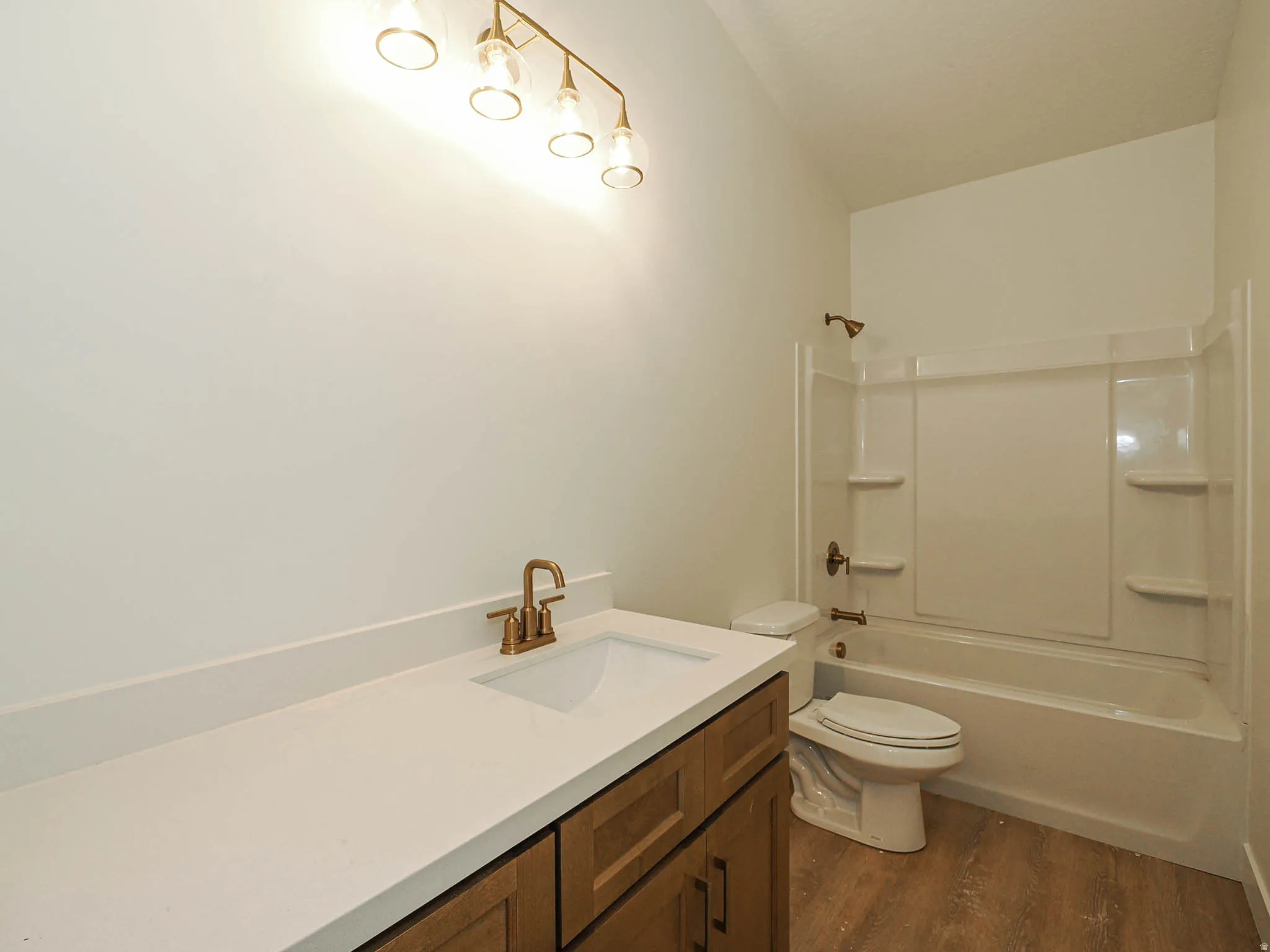 Bathroom featuring a single vanity with a white countertop, an integrated sink, and bronze-finish fixtures