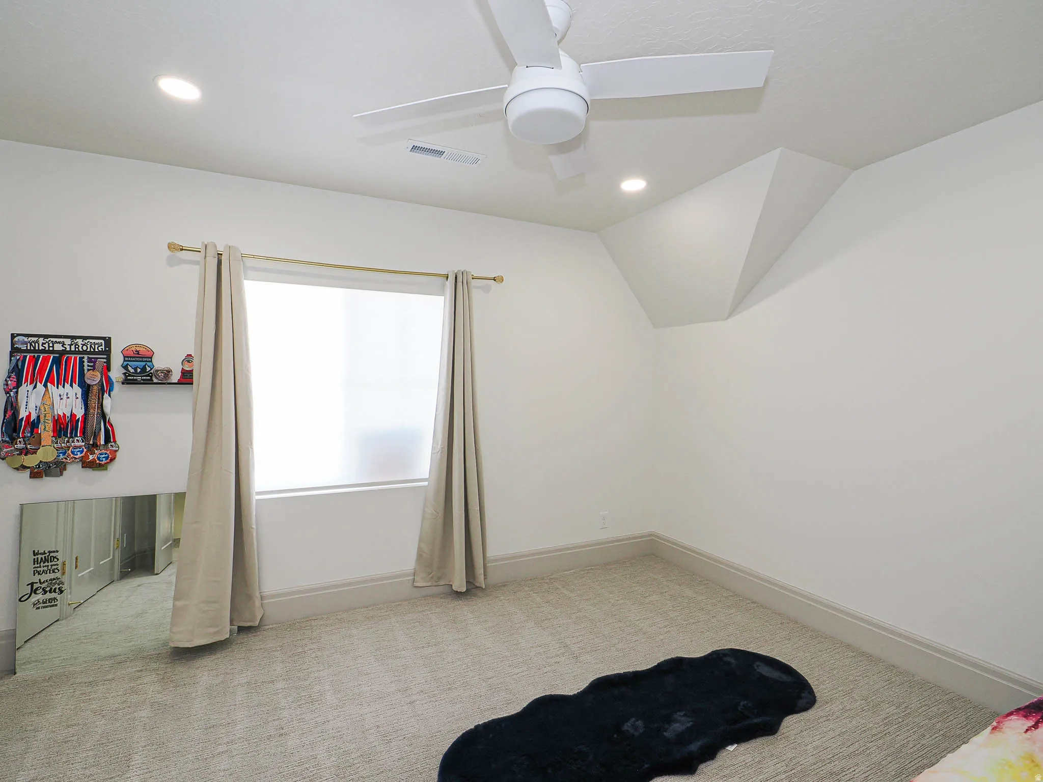 Neutral wall paint with recessed lighting, a ceiling fan, a window, and textured carpeting