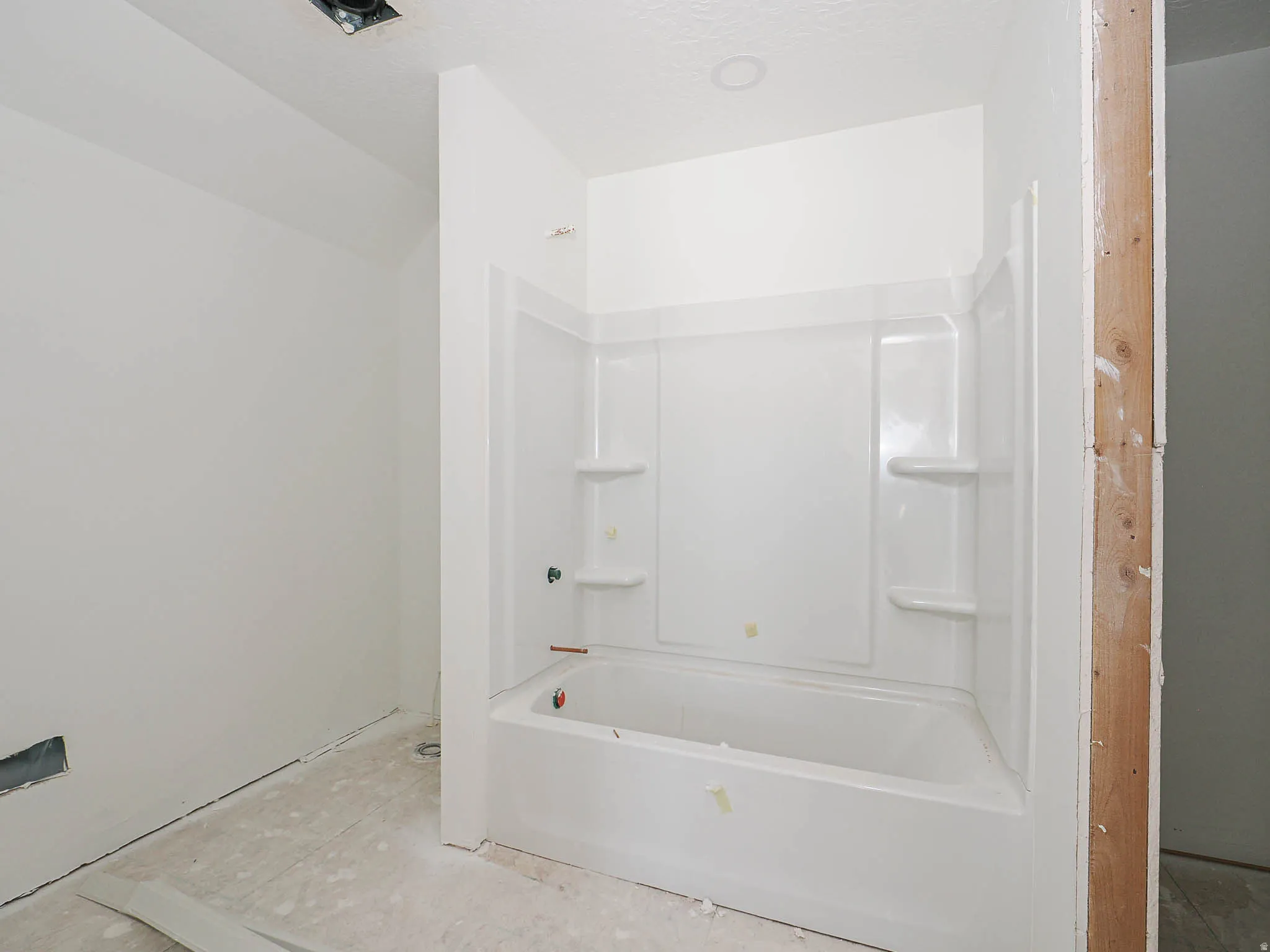 White acrylic tub and shower combination with integrated shelving