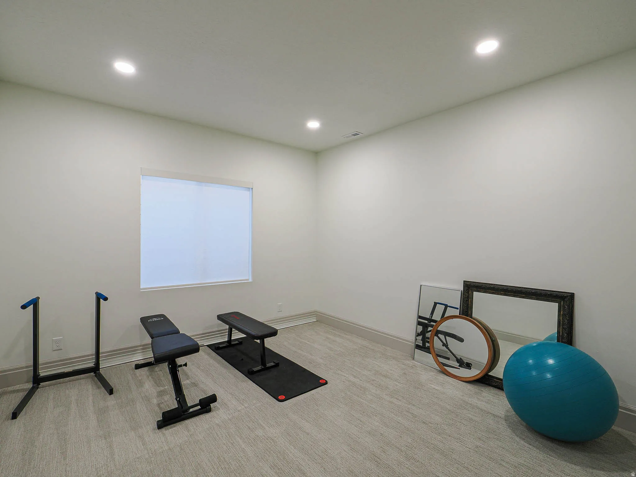 Versatile room with recessed lighting, light-toned walls, and wood-finish flooring