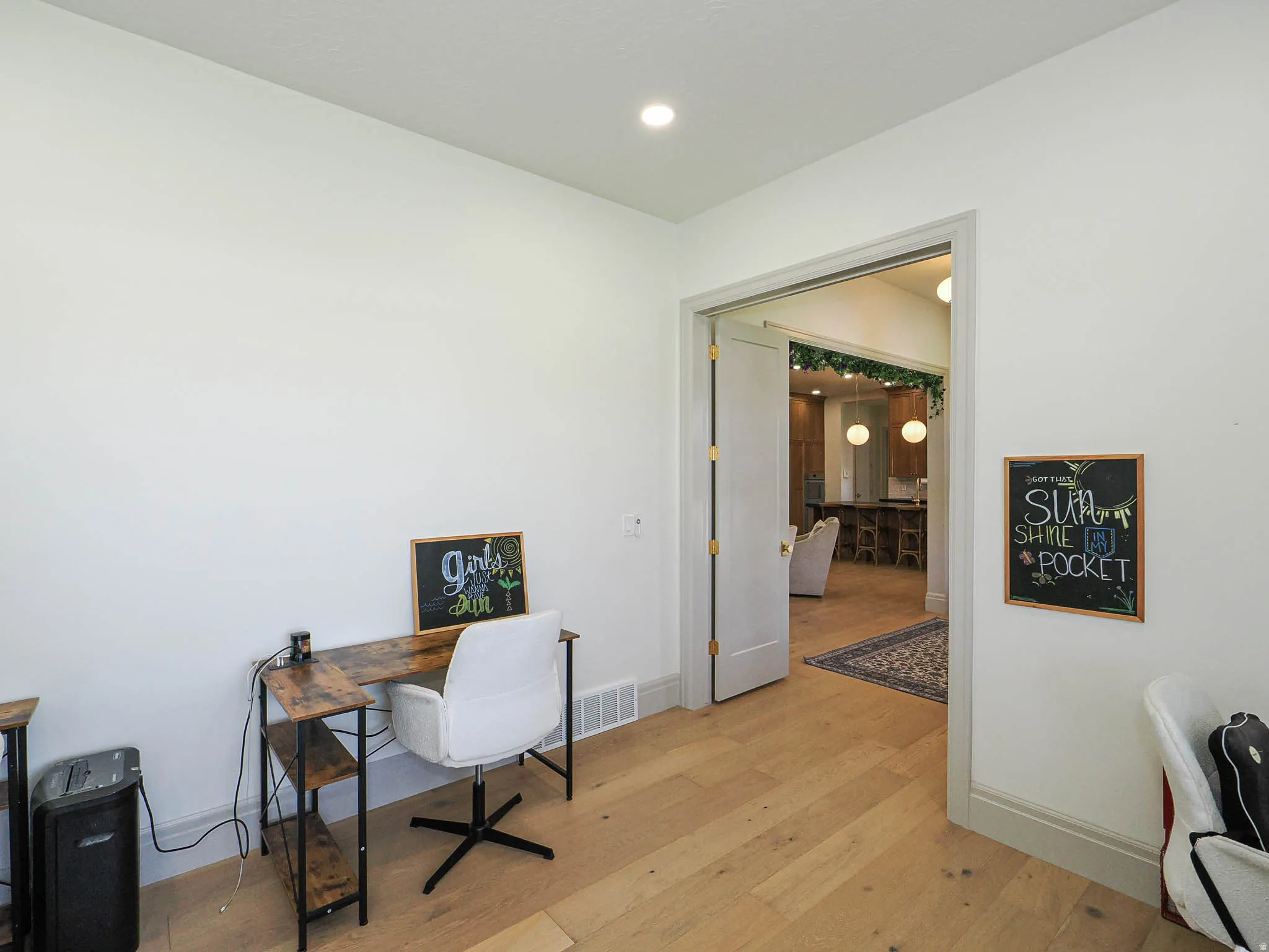 Room with light wood-finish flooring, white walls, and a recessed ceiling light