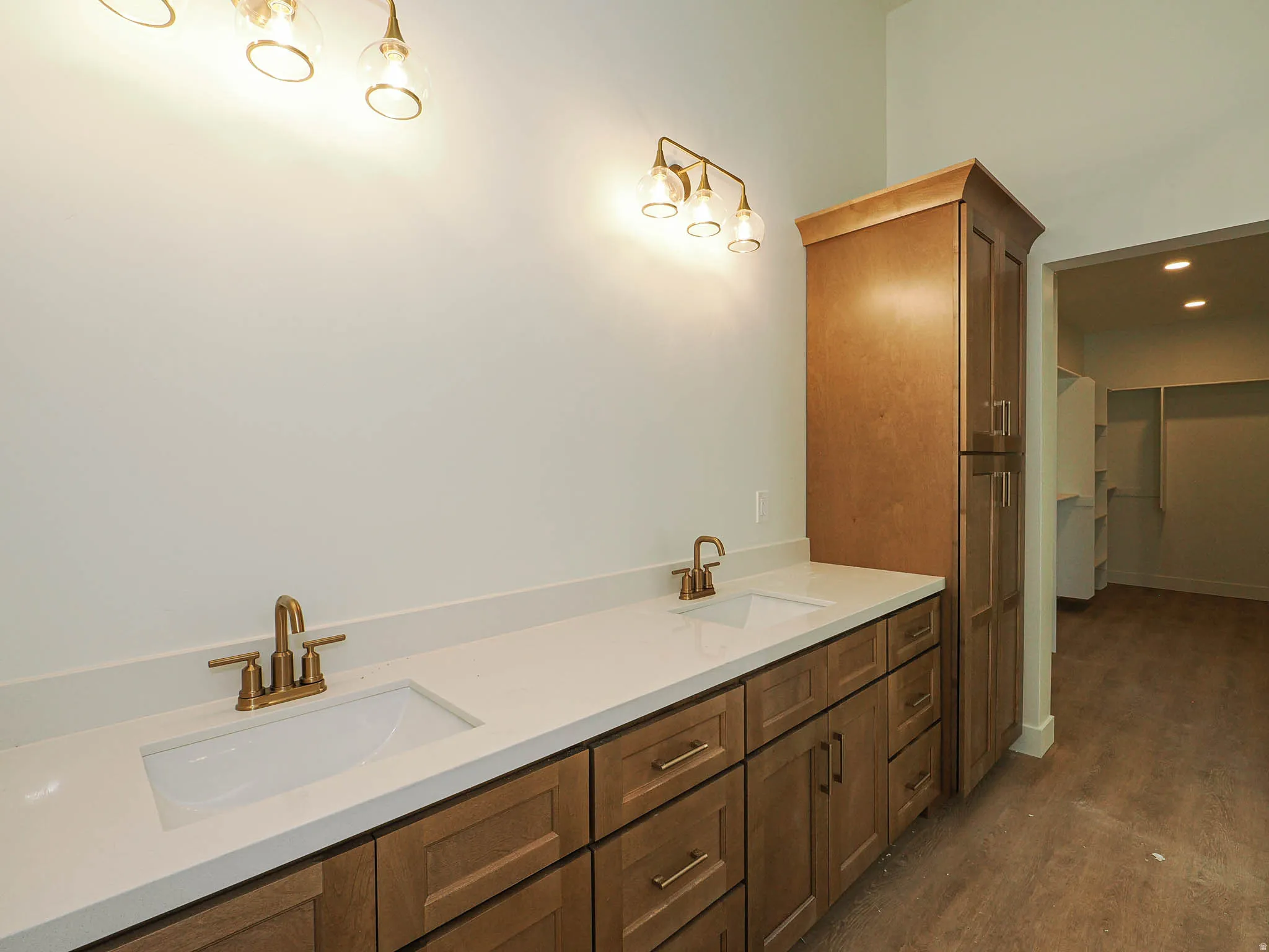 Dual vanity with white undermount sinks, bronze faucets, and a light-toned countertop
