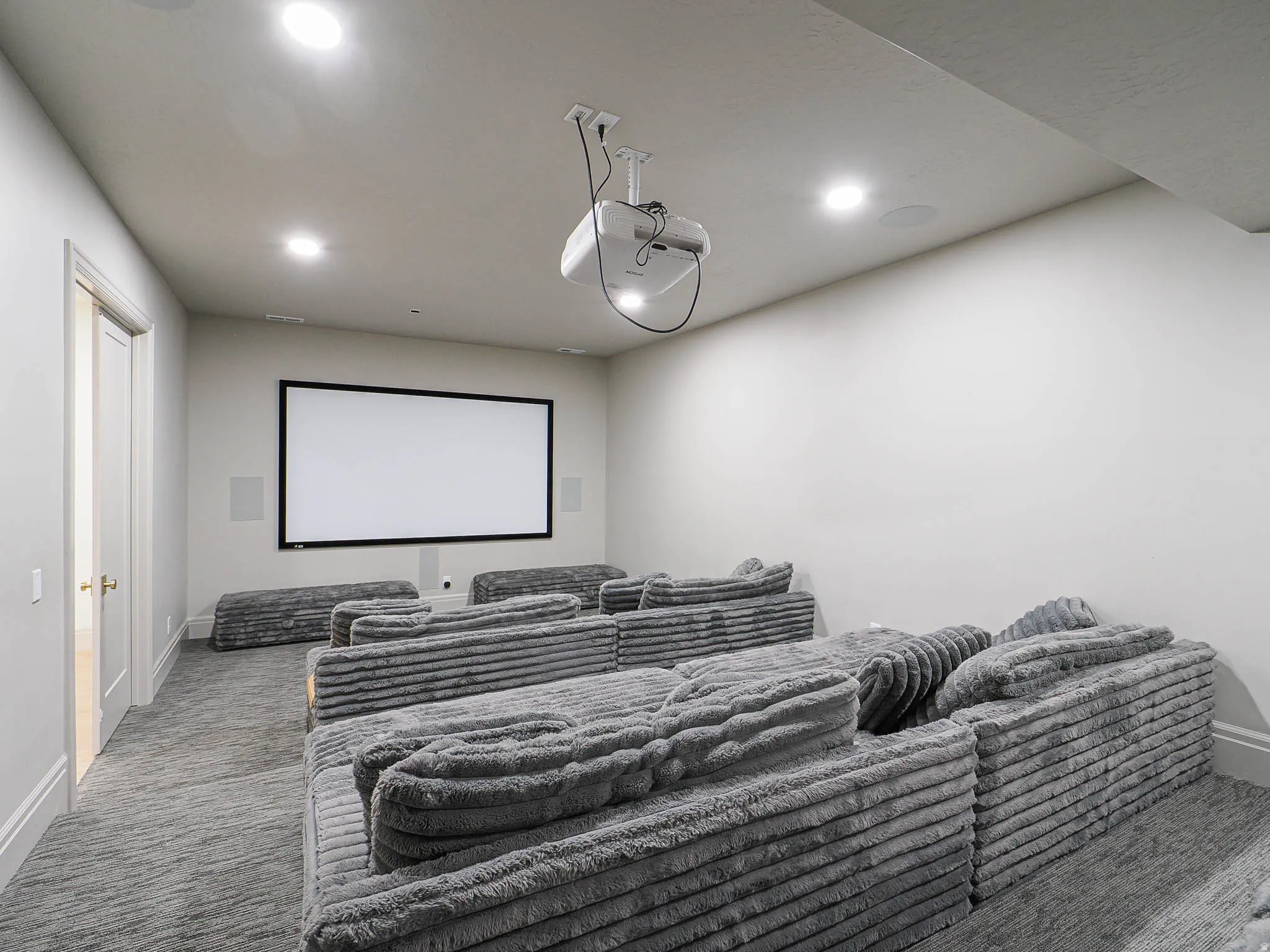 Dedicated media room featuring a large projection screen and built-in ceiling projector