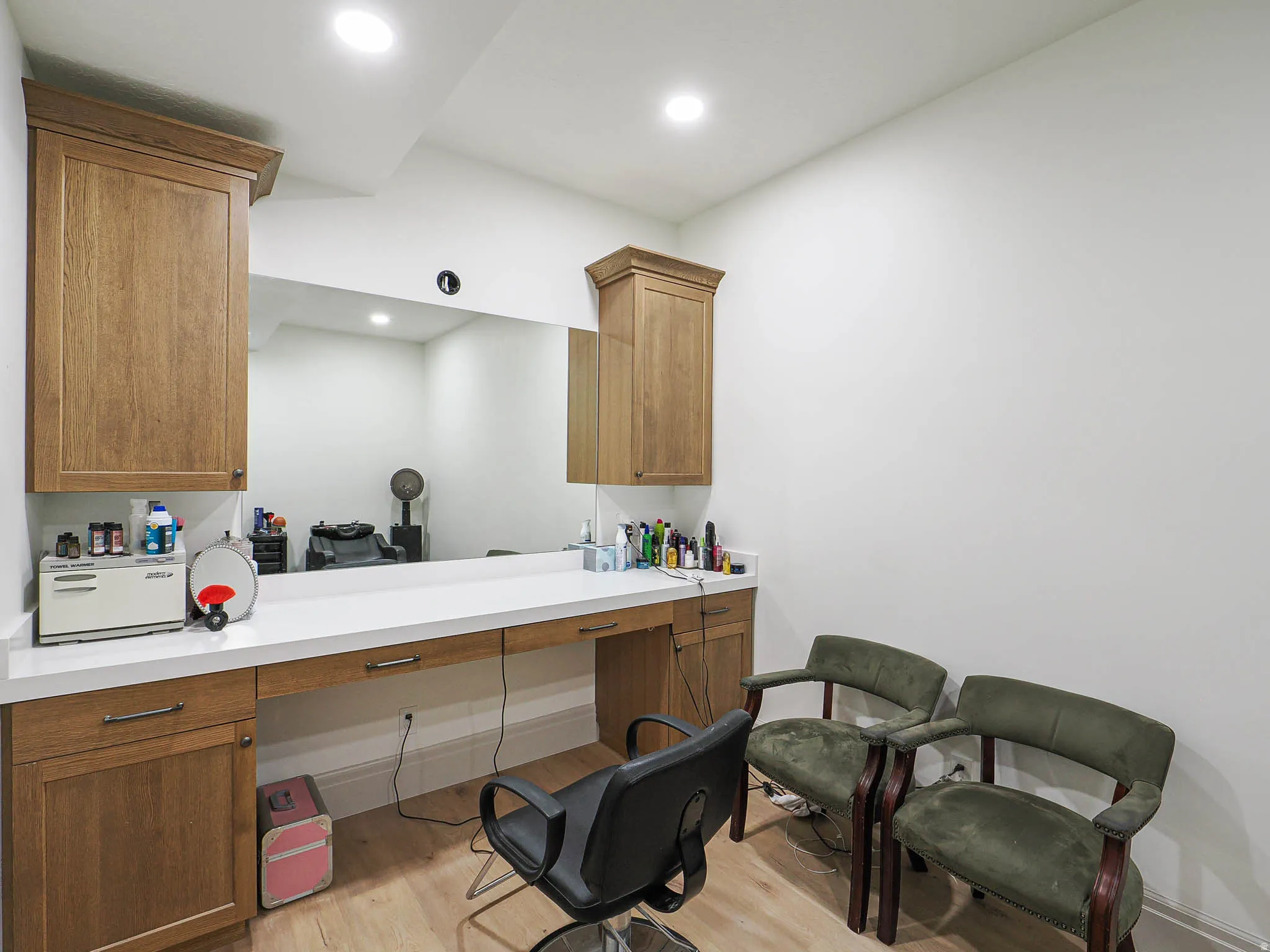 Built-in cabinetry with crown molding, a white countertop, and a large wall-mounted mirror