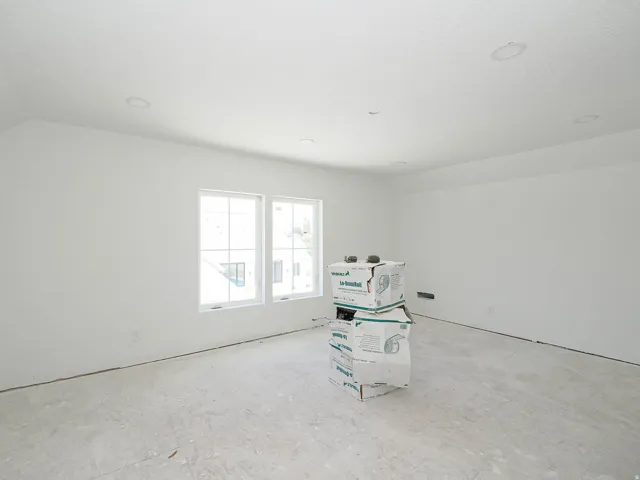 Spacious room with white walls, dual windows, and recessed lighting