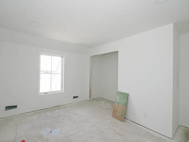 Room under construction featuring a window, recessed ceiling lighting, and a doorway opening
