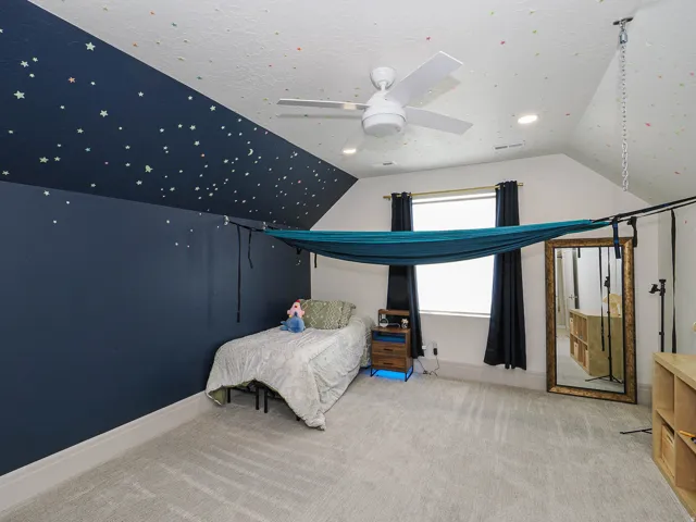 Carpeted room featuring a vaulted ceiling with recessed lighting and a ceiling fan