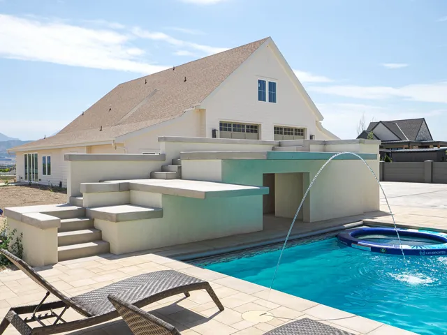 Outdoor swimming pool featuring a water fountain, surrounding patio, and tiered concrete steps