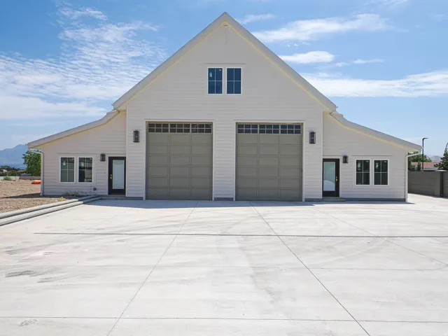 Two-story structure with white horizontal siding and a prominent gable roofline