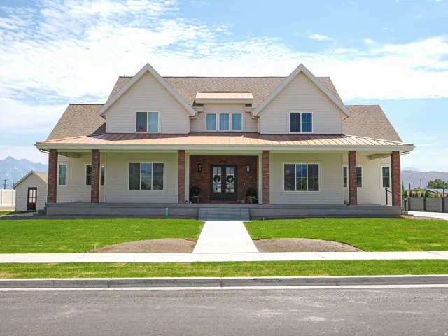Two-story residence featuring light-toned siding and a brown shingle roof