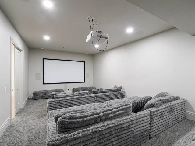 Dedicated media room featuring a large projection screen and built-in ceiling projector