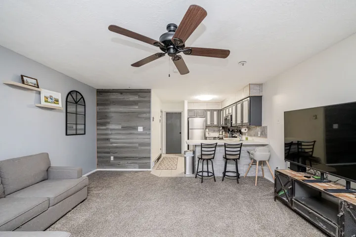 Open-concept living area with a wood-finish accent wall