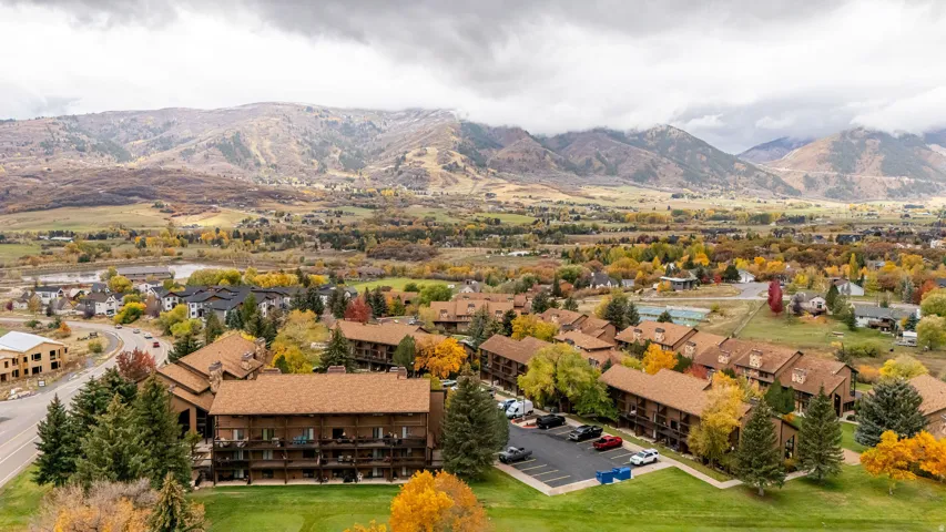 Mountain-backed community featuring multi-story buildings with brown exteriors and balconies