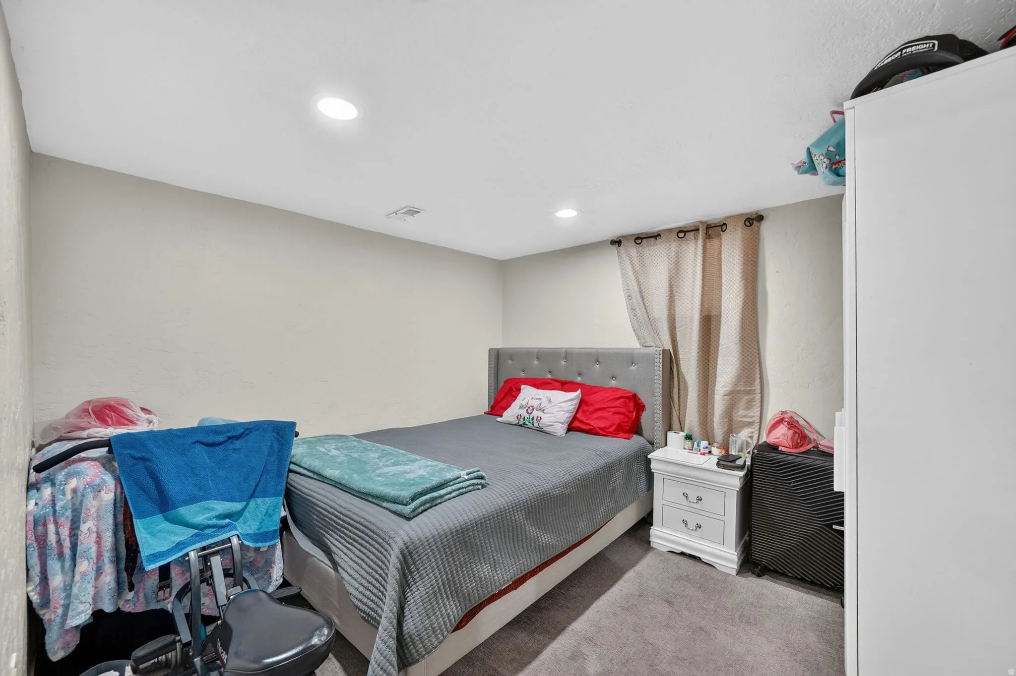 Recessed lighting illuminates neutral-toned walls and gray carpeting