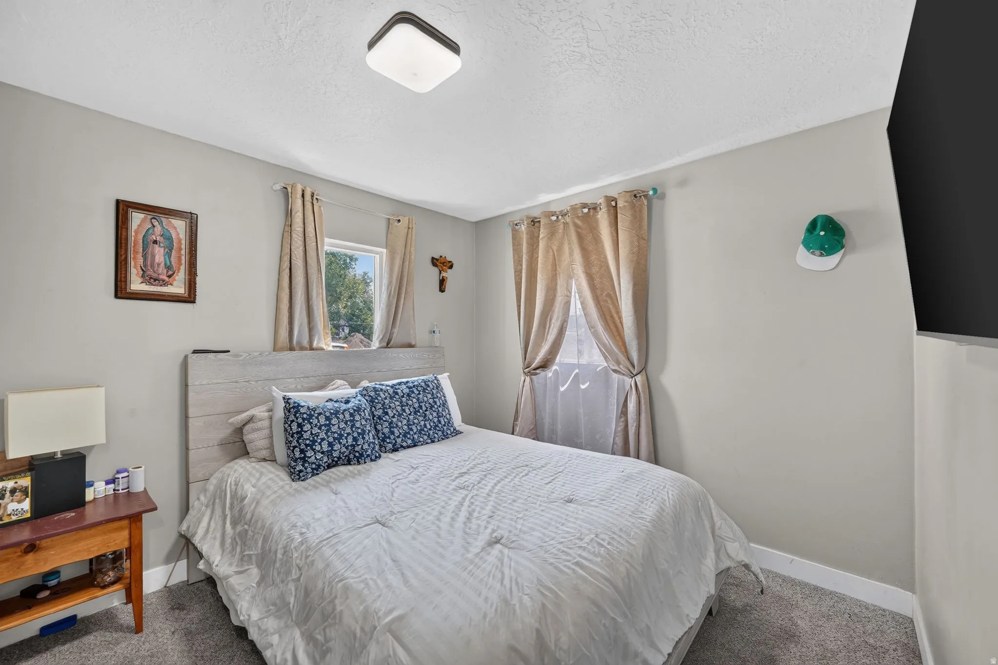 Bedroom featuring light gray wall paint, a window with natural light, and dark gray carpeting