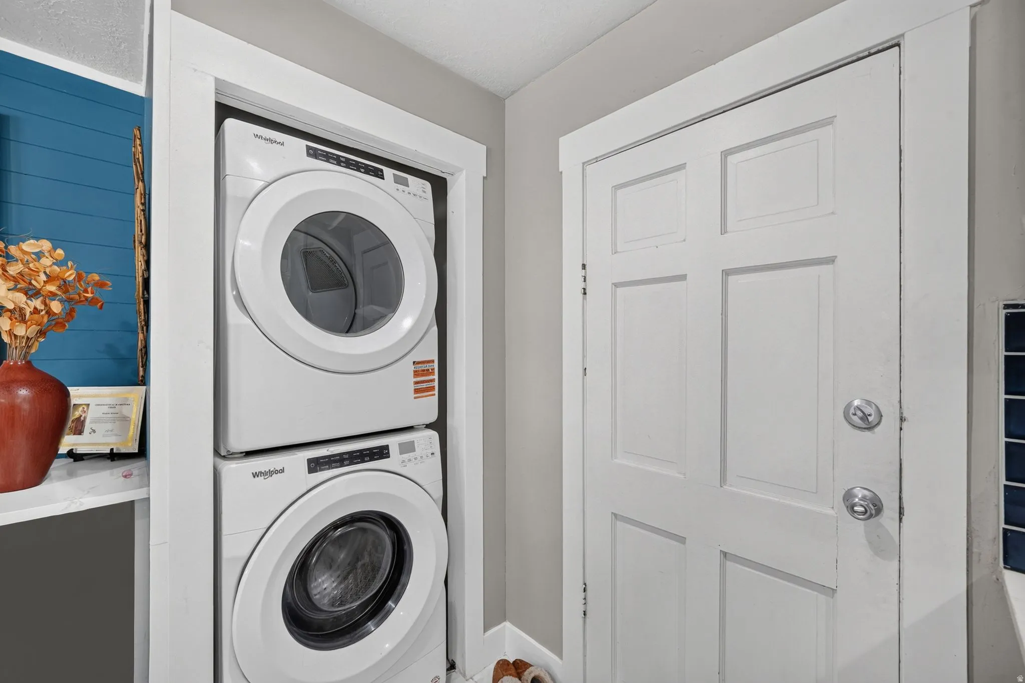 Dedicated laundry area featuring a stacked washer and dryer unit