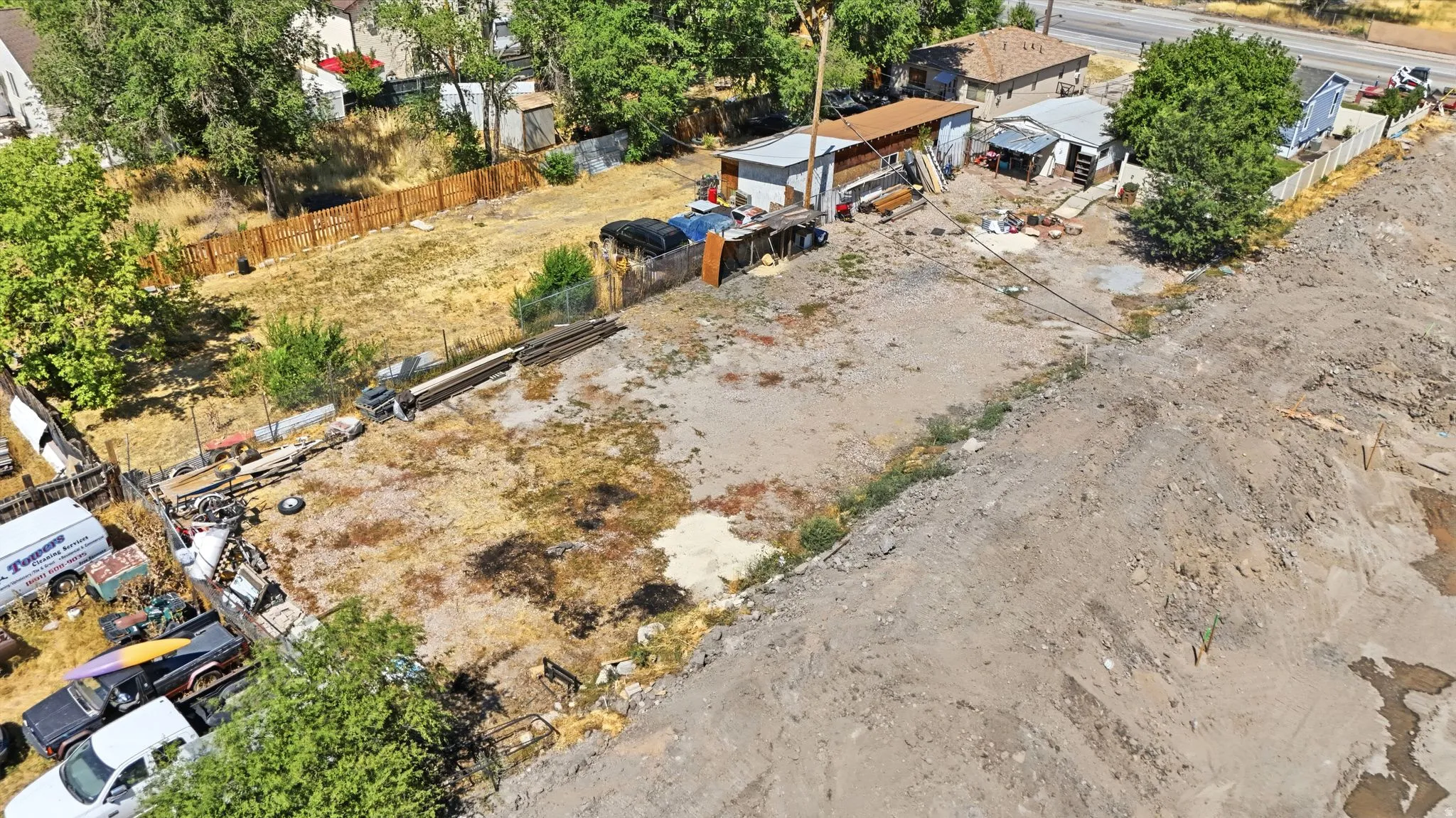 Expansive undeveloped lot featuring a partially cleared area and a backdrop of mature trees