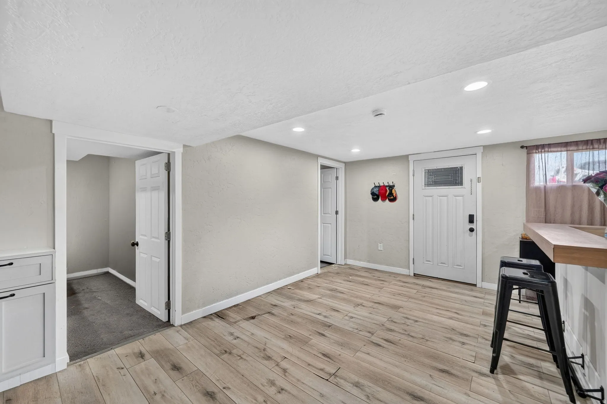Spacious room featuring wood-finish flooring, recessed lighting, and a neutral color palette