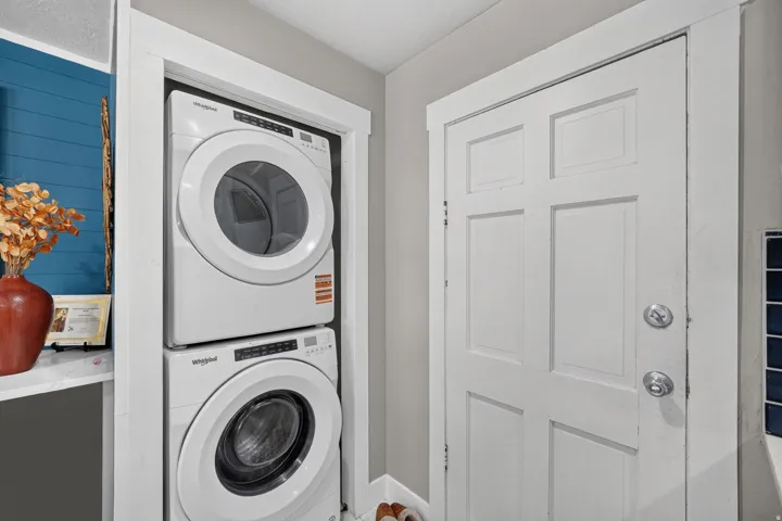Dedicated laundry area featuring a stacked washer and dryer unit